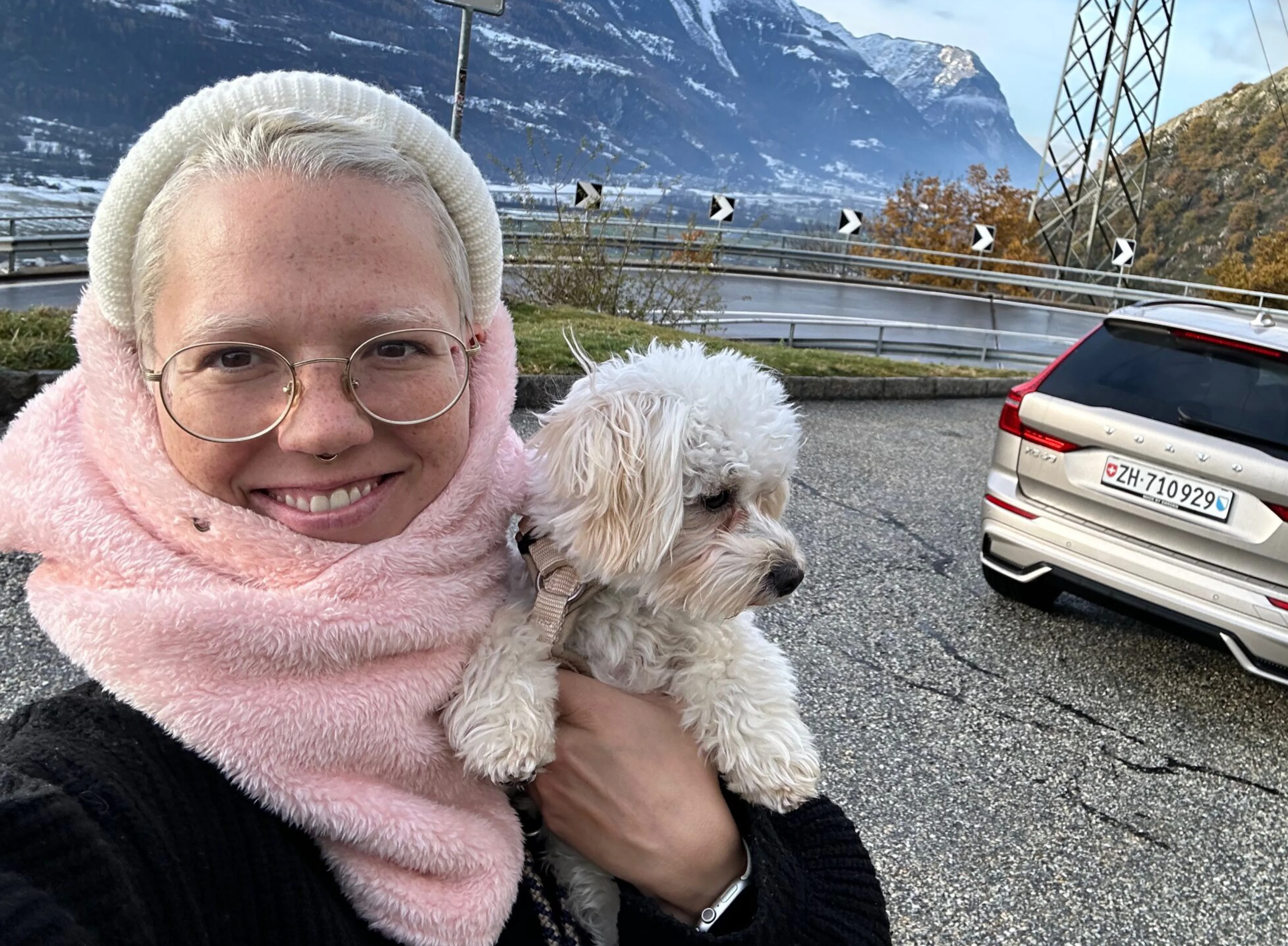 Aufnahme von Stefanie Heinzmann, die einen kleinen, weissen Hund auf dem Arm hat.
