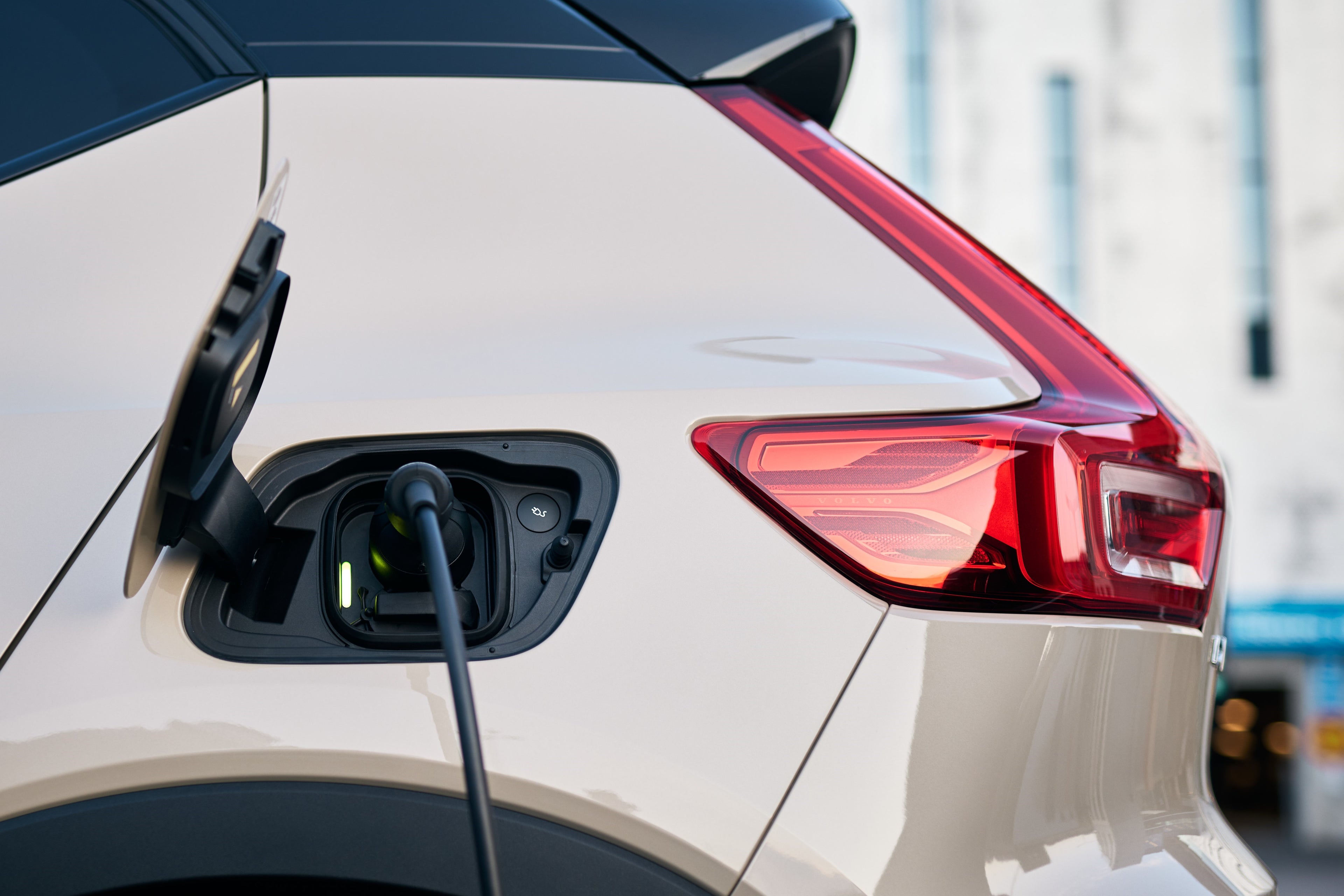 Ein Volvo EX40 Sand Dune Edition mit eingestecktem Ladekabel