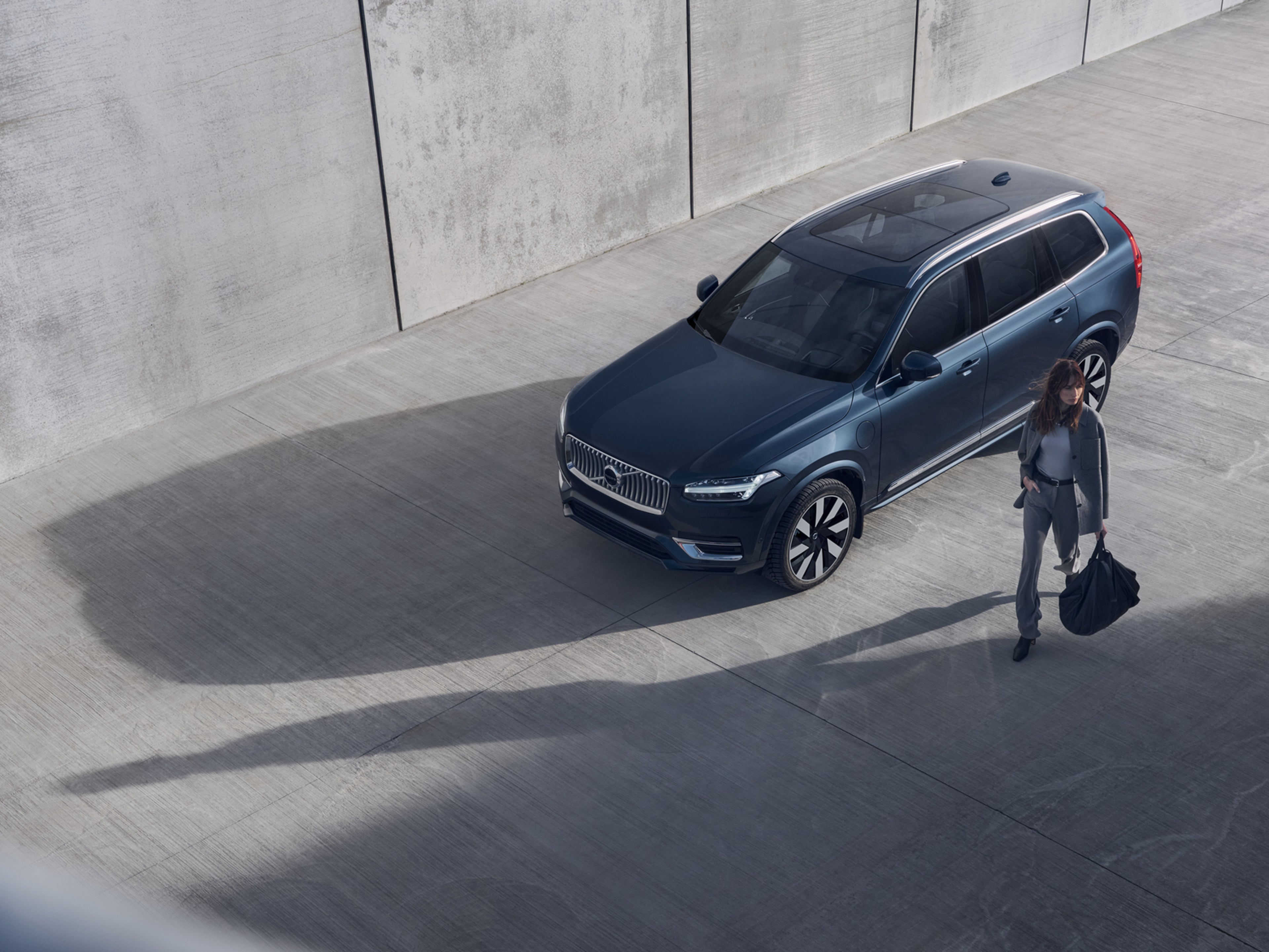 žena kráčajúca pri vozidle Volvo XC90