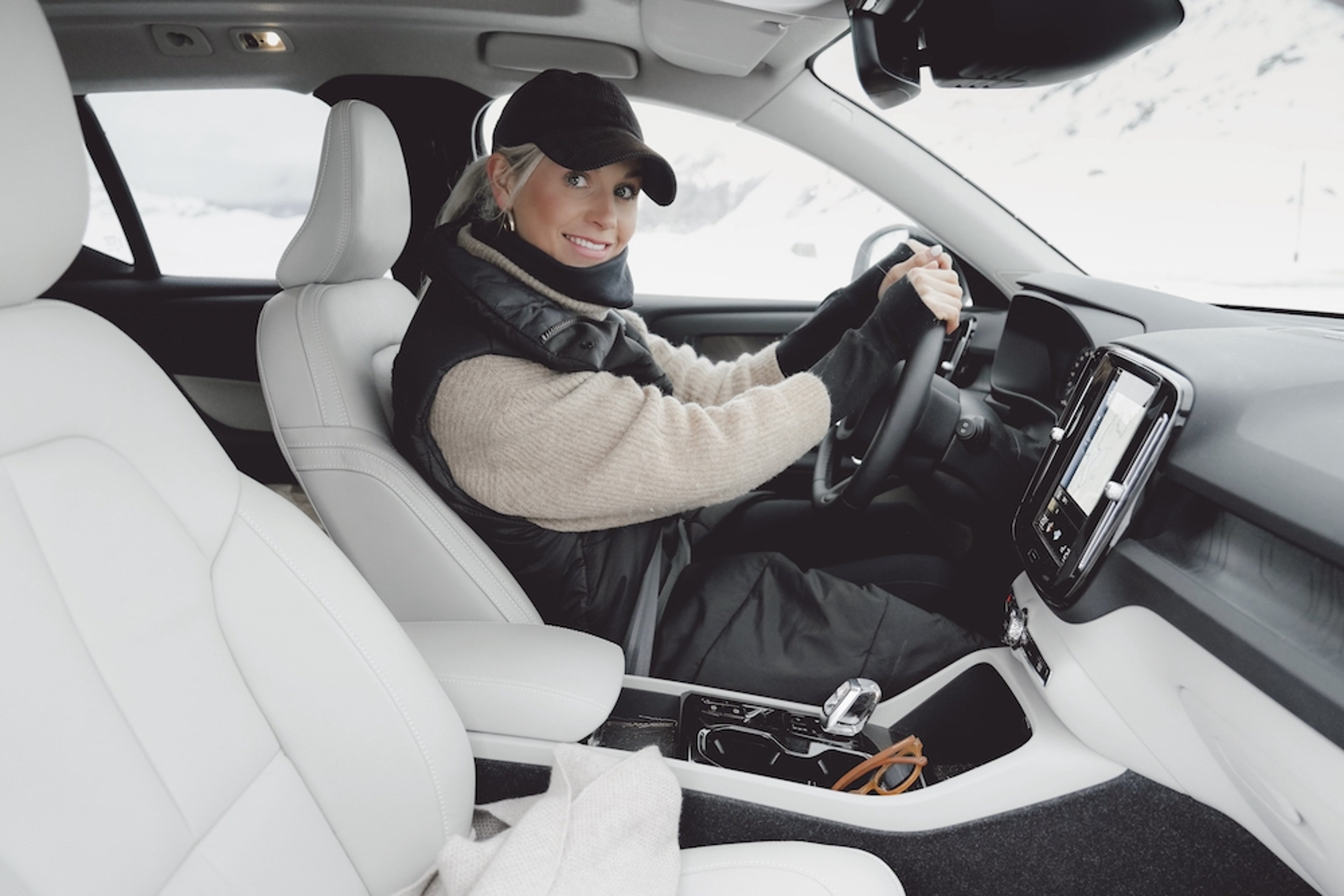 Nadia Damaso, eine blonde Frau sitzt in Ihrem Volvo mit weißer Innenausstattung.