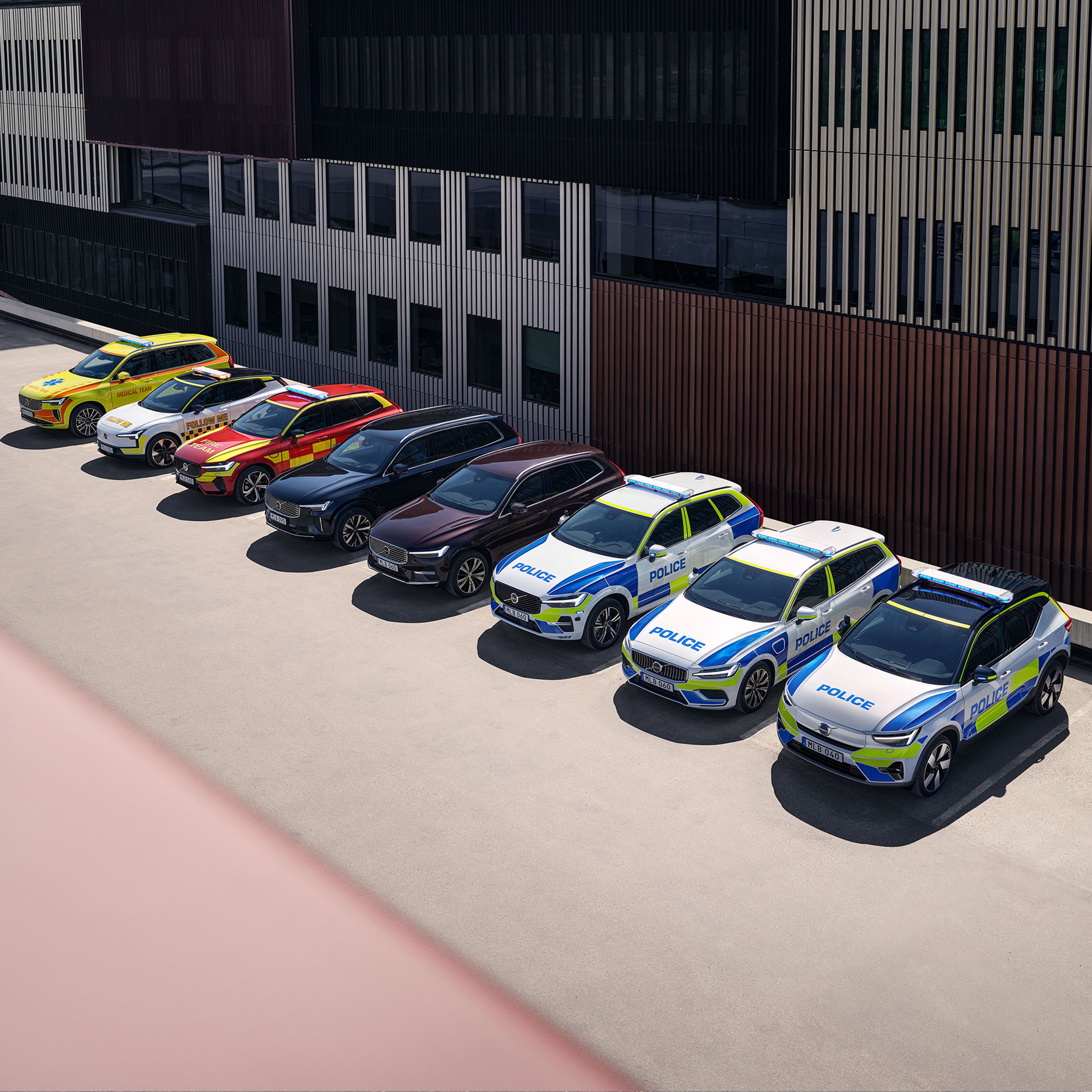 Tre auto della polizia Volvo e tre SUV Volvo blindati parcheggiati all'esterno di un edificio ufficiale.