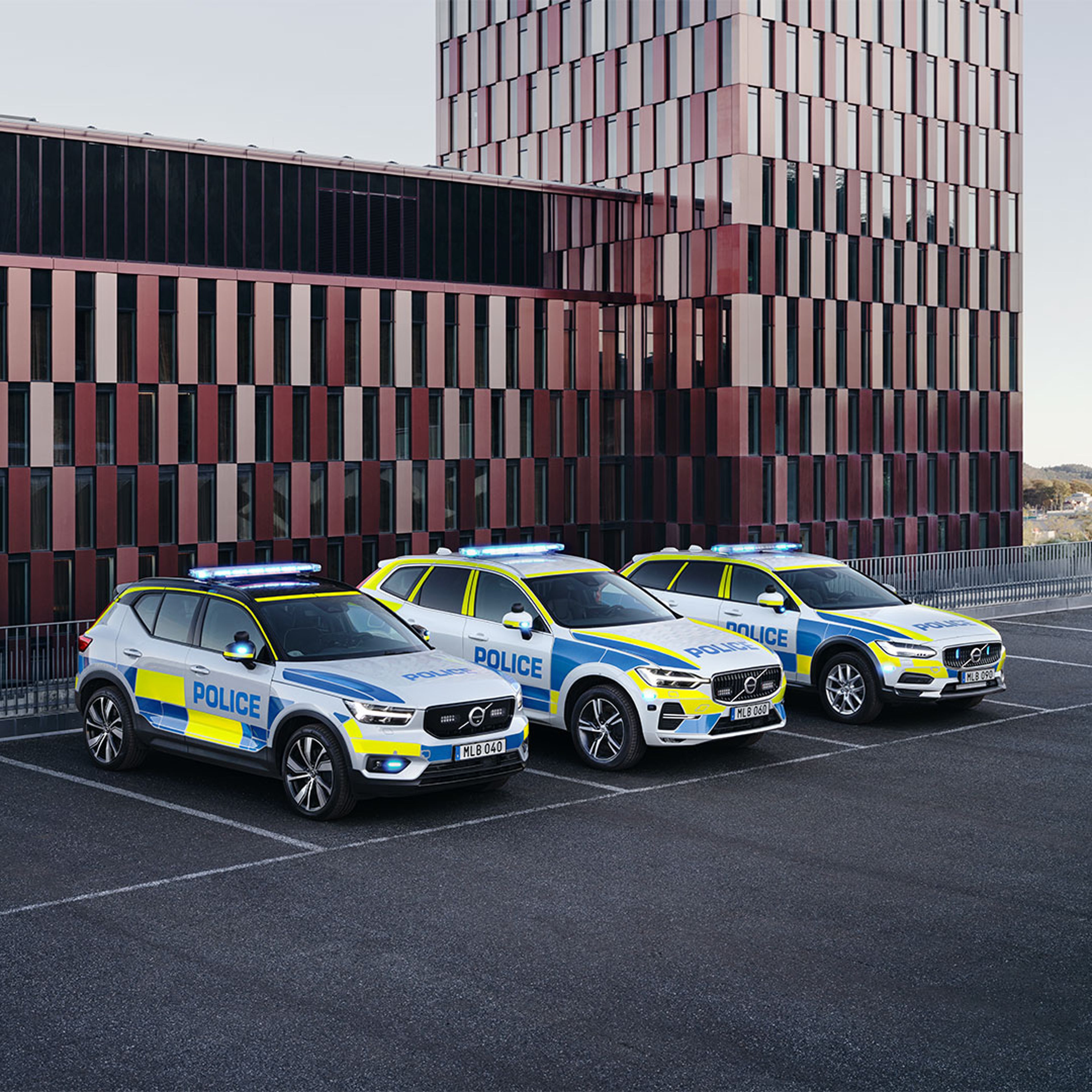 De volledig elektrische Volvo XC40 Recharge, XC60 en V90 Cross Country politieauto's geparkeerd voor een overheidsgebouw.