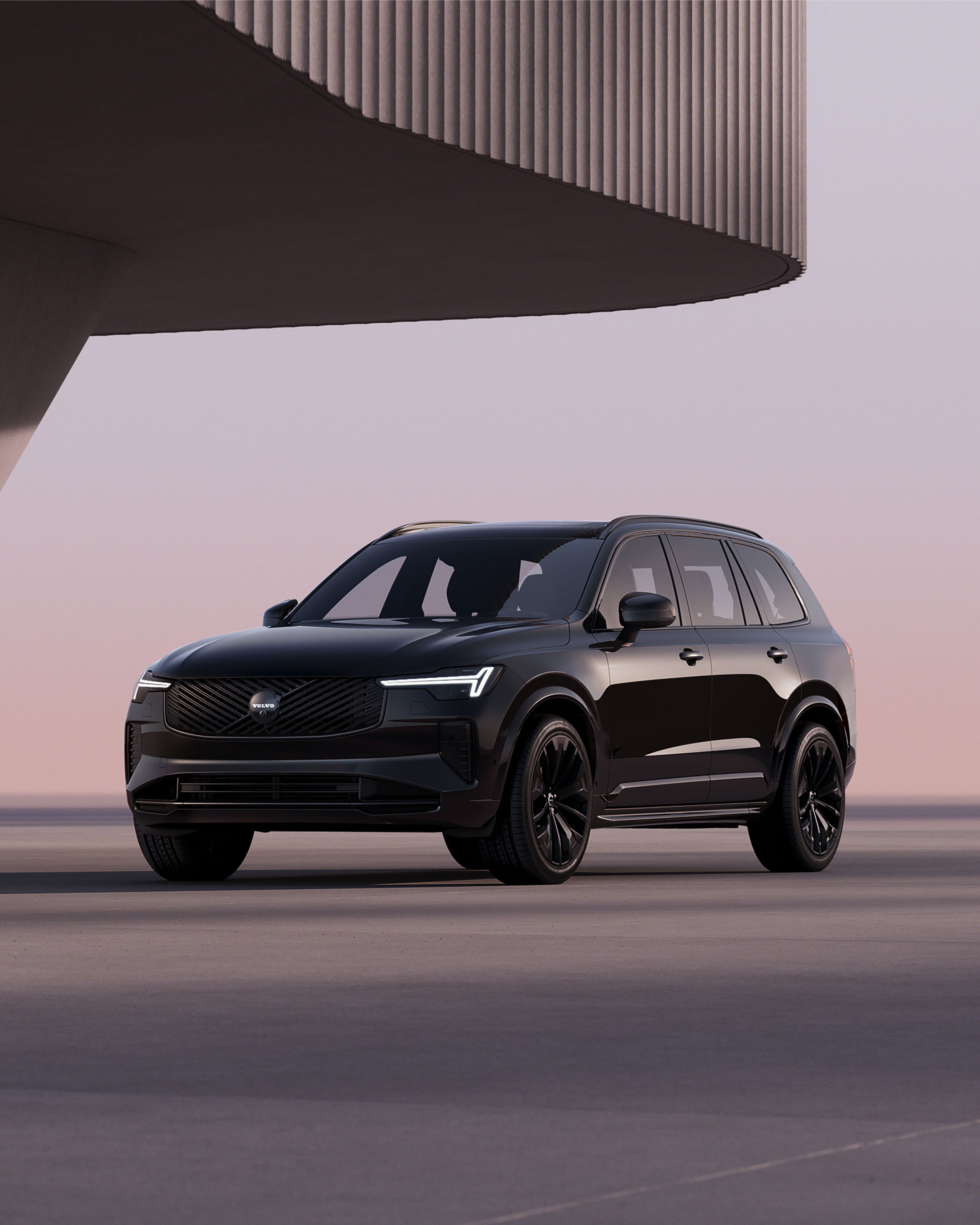 Ein Volvo XC60 als Black Edition steht vor einem Panorama Sonnenuntergang Hintergrund