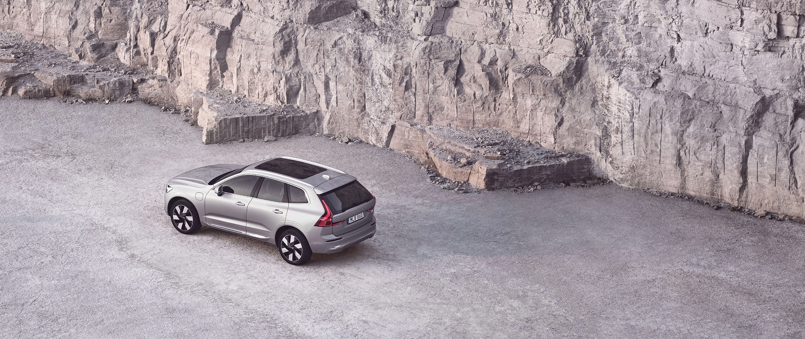 An aerial shot of a Volvo SUV car in a rocky outdoor environment