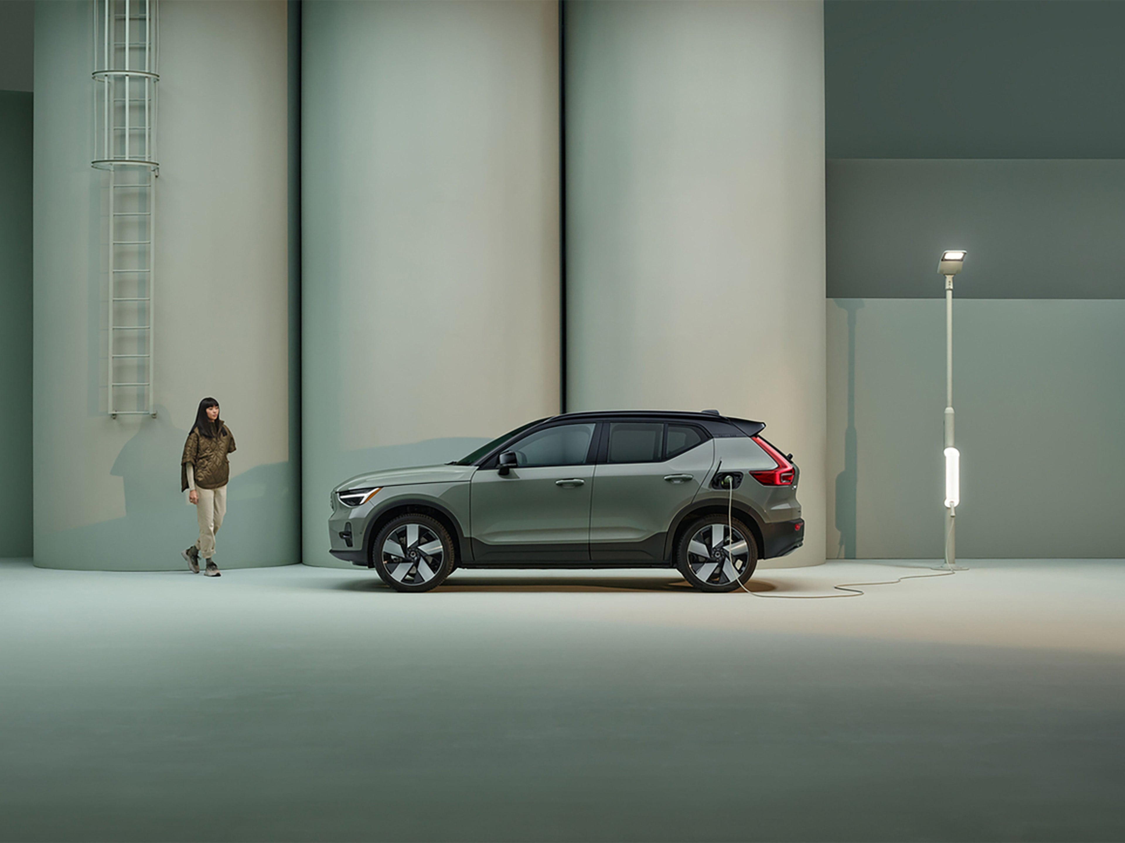 Electric Car Charging Point on the Road - Woman walking by an electric car