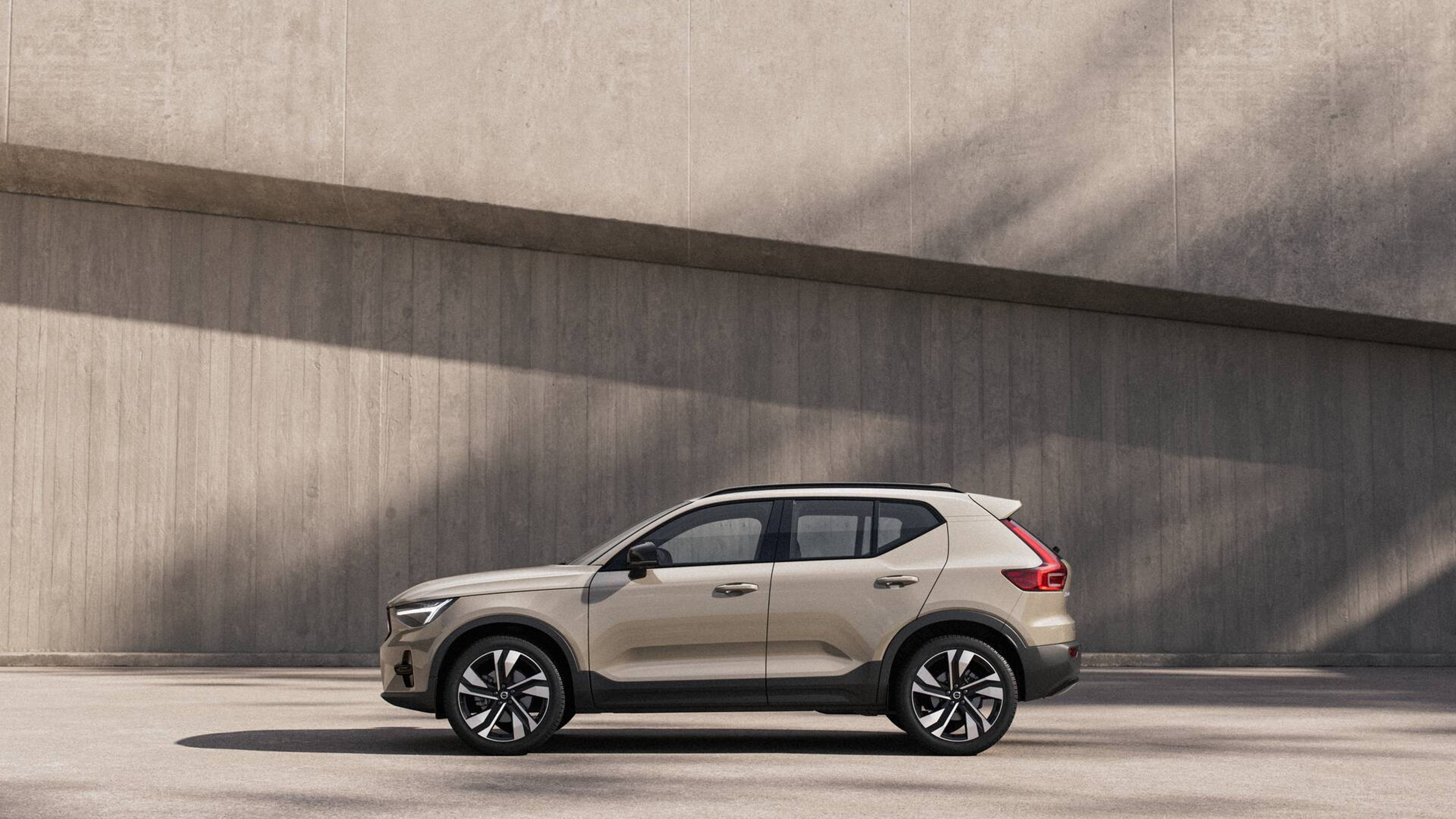 Uma mulher desfocada está no meio de uma rua com um Volvo EX90 visível atrás dela.