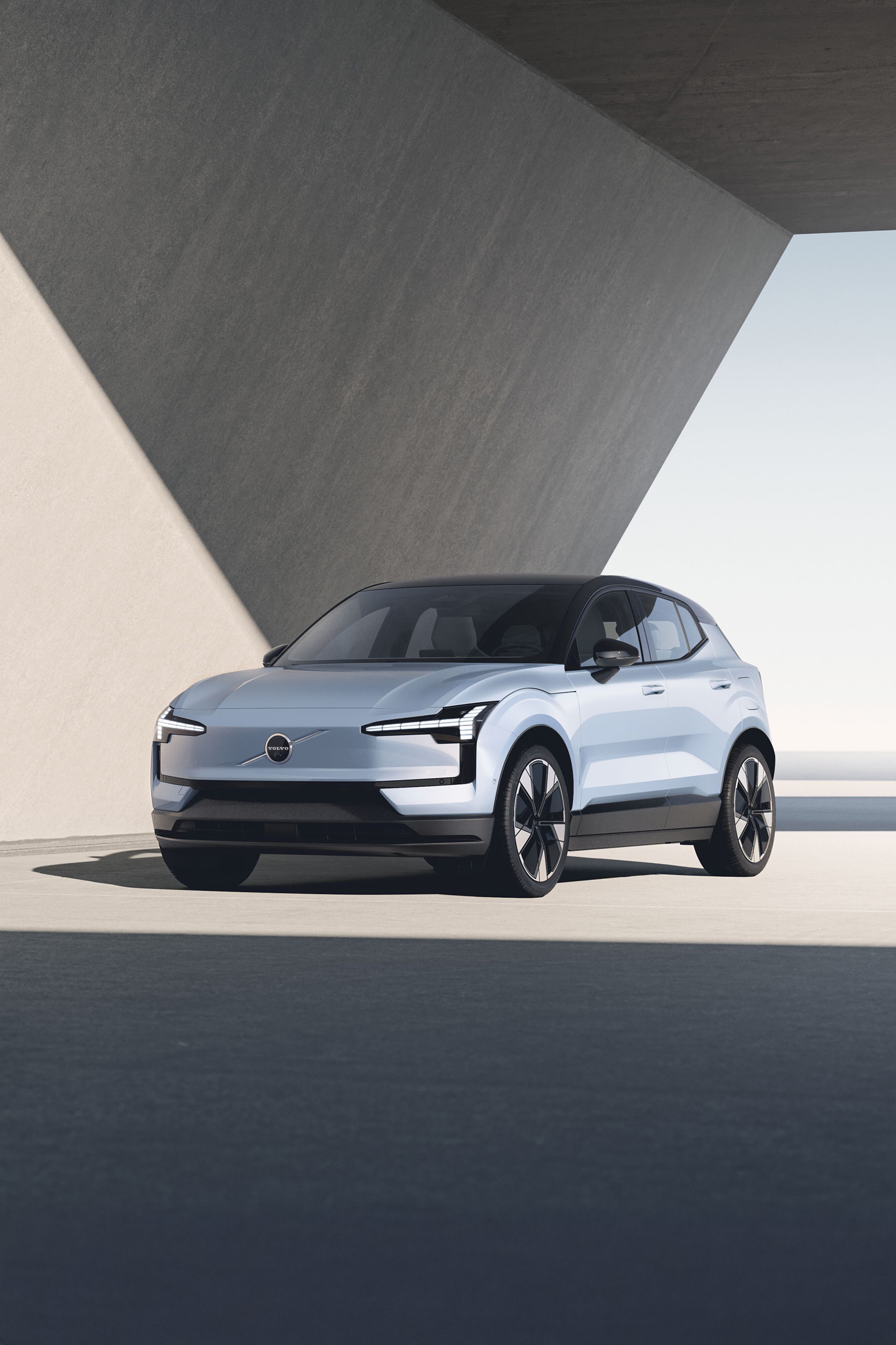 EX30 Cross Countryが砂利道に停車しており、その背景には雄大な山々が広がっています。