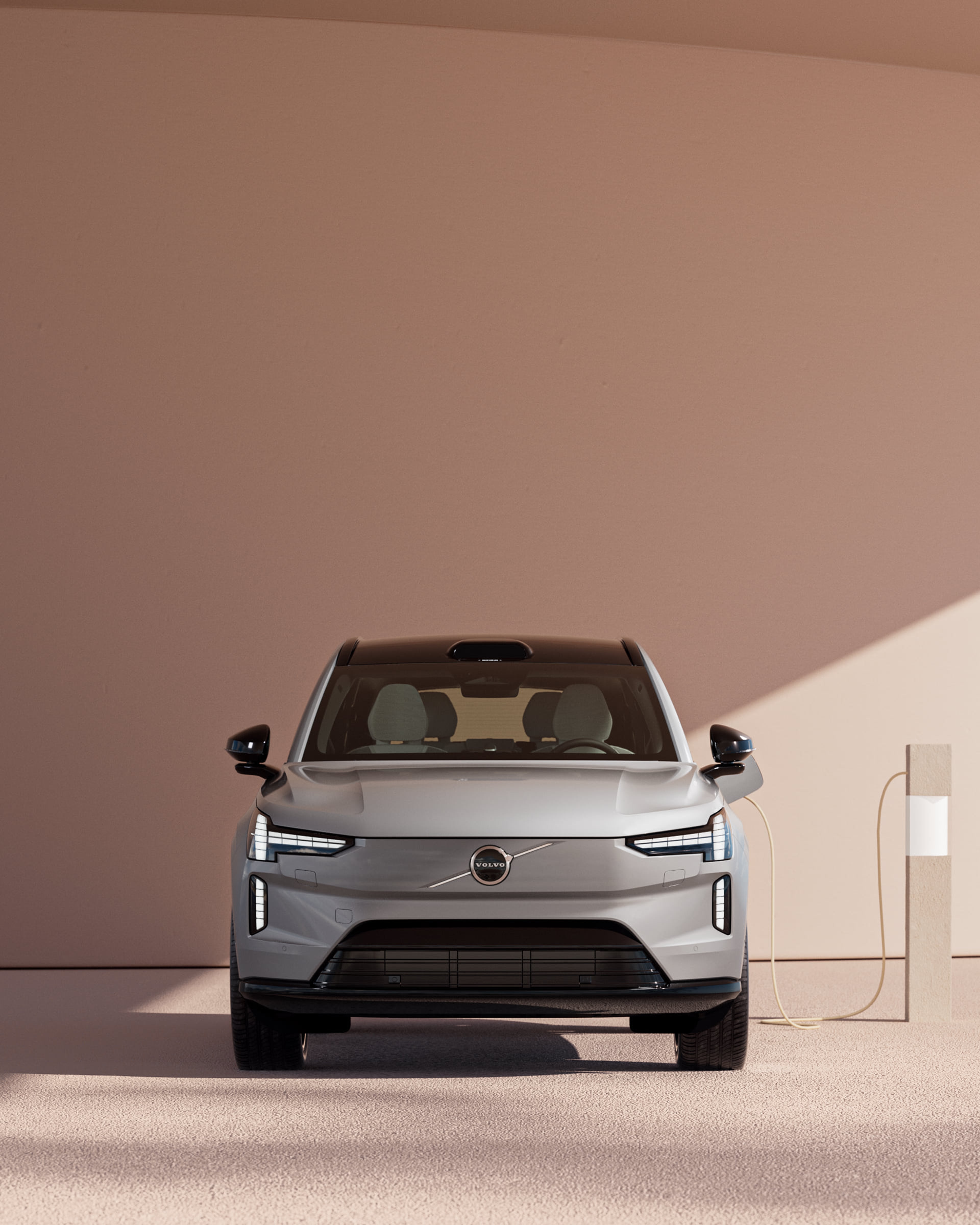 Front view of the fully electric Volvo EX90 SUV in Vapour Grey charging.