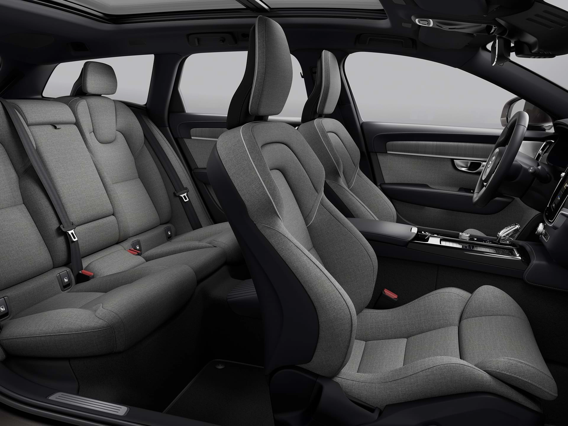 Vue panoramique des quatre sièges recouverts de tissu de l'habitacle d'un spacieux break Volvo.
