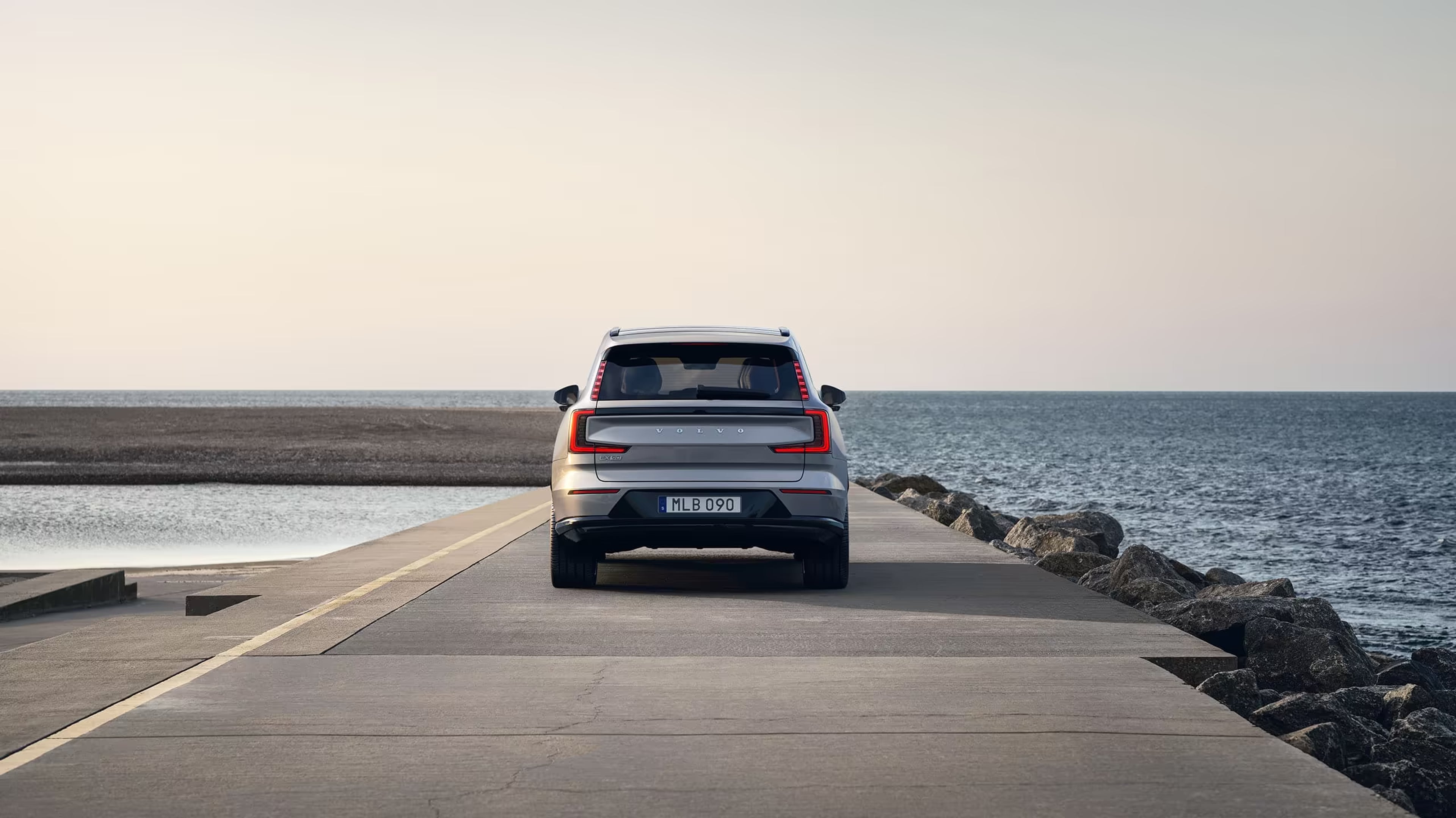 Takanäkymä Volvo EX90 pysäköitynä merelle päin.