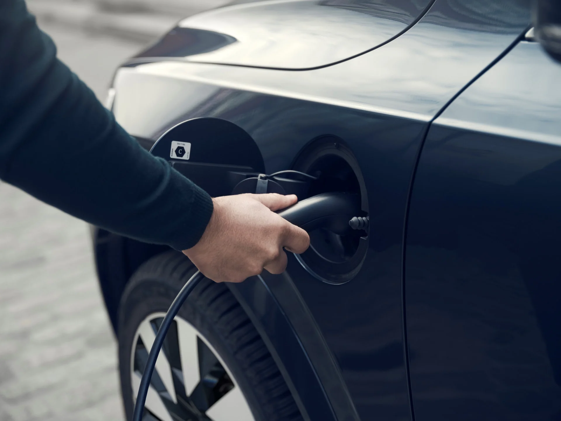 An image showing a charging cable connected to a Volvo XC90.