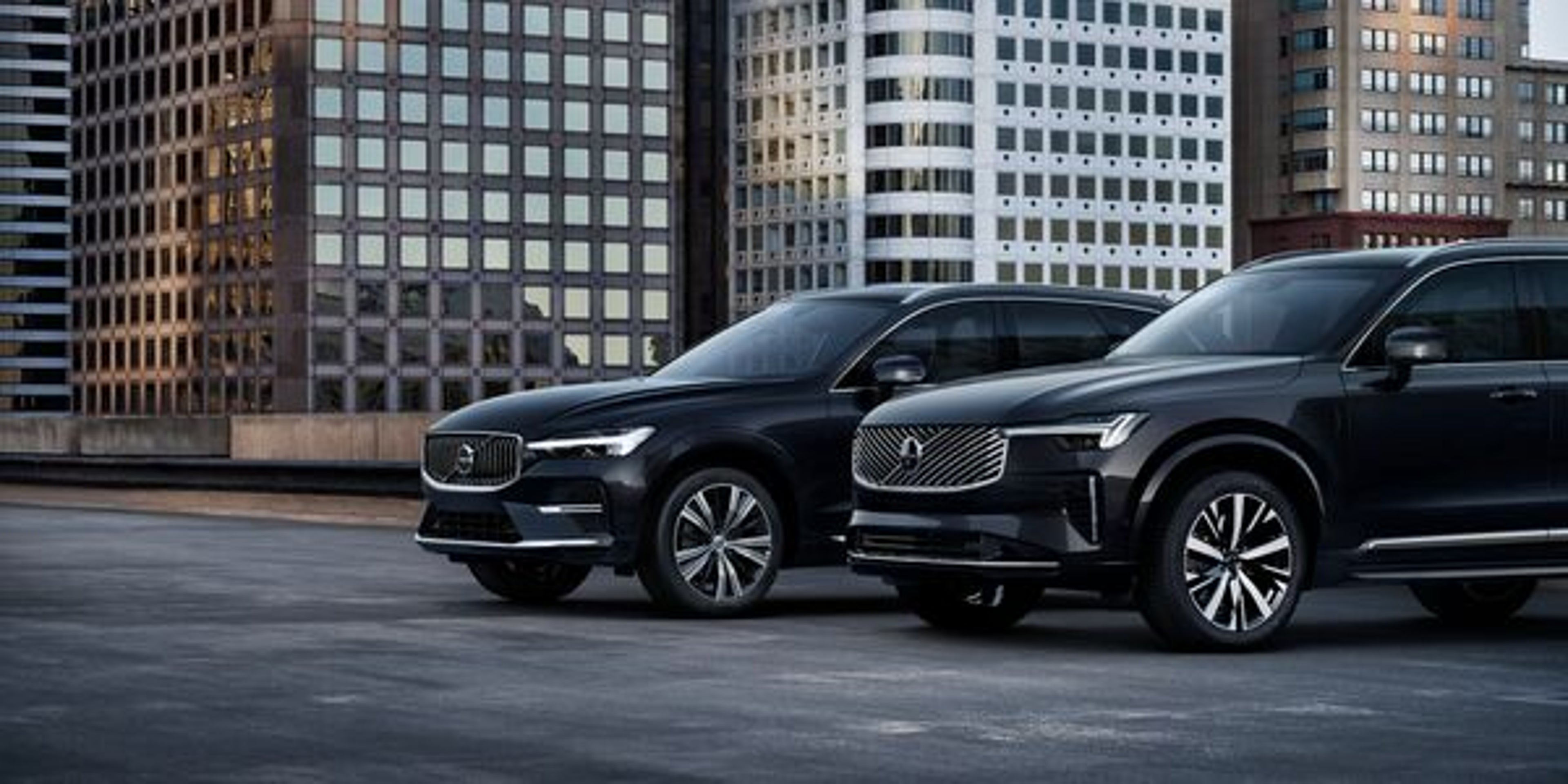 Vooraanzicht van de lichtgepantserde Volvo XC60 en XC90 op een parkeerplaats in een financieel district.