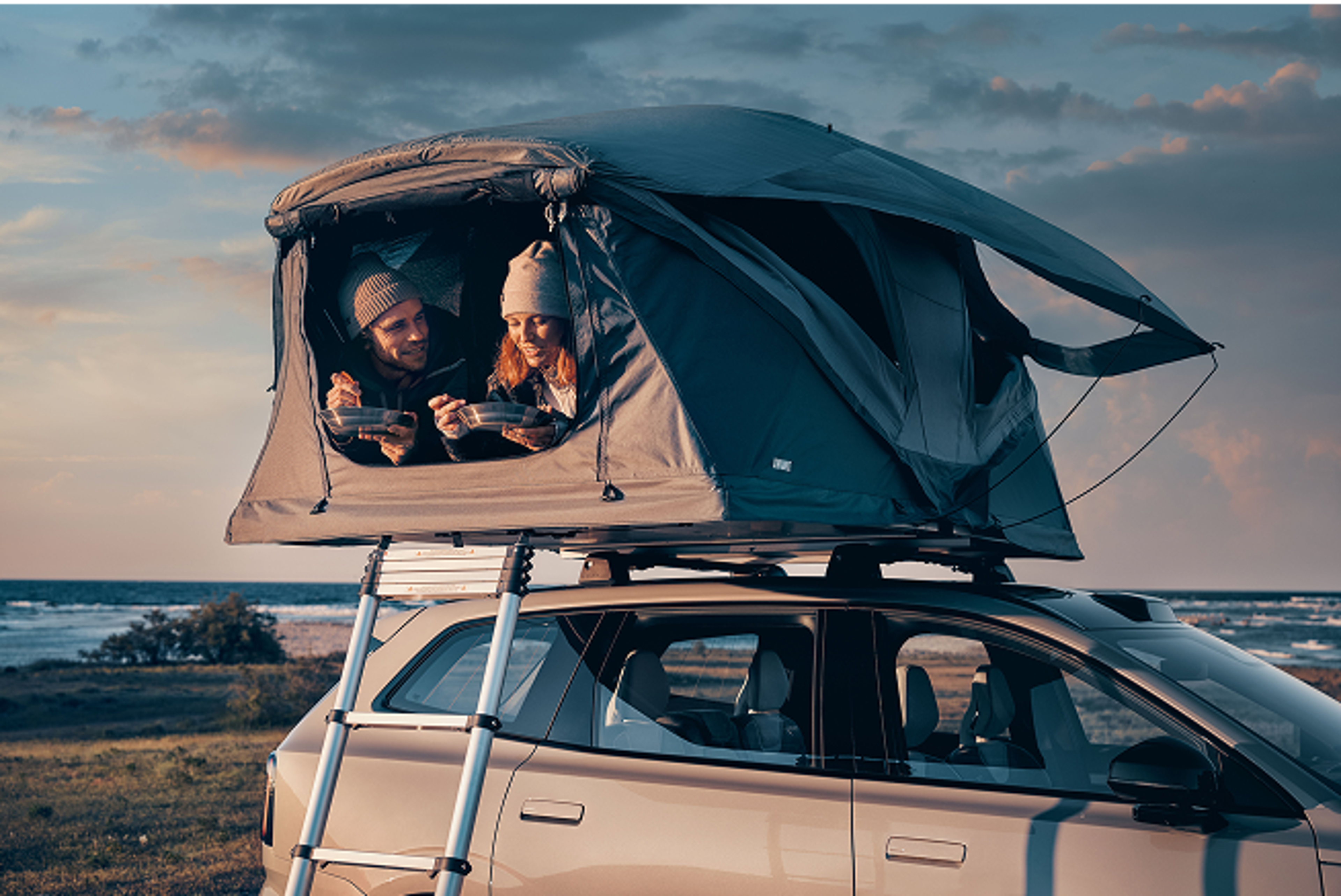 Woman and Volvo staff member talking beside a car inside a showroom or service area.