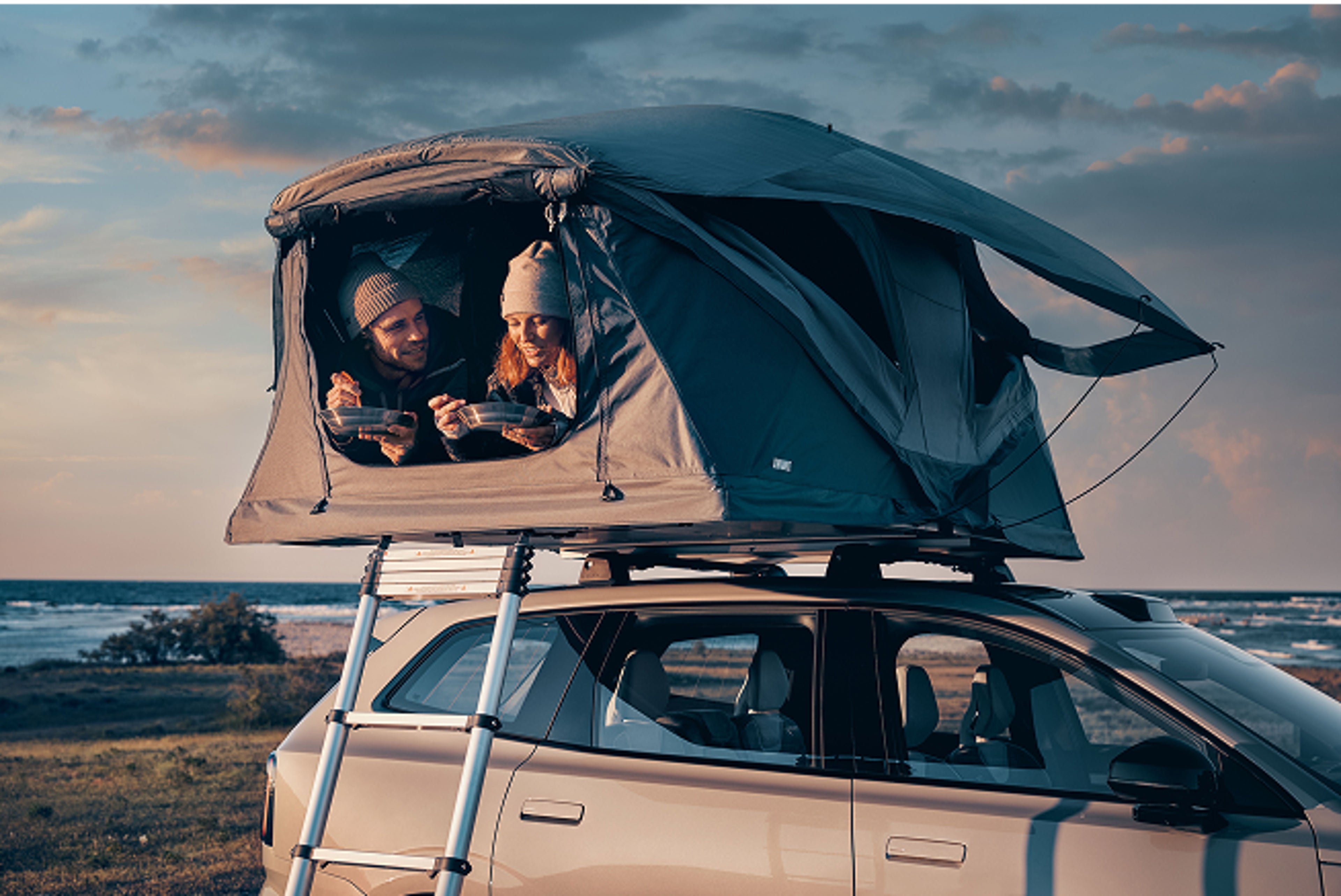 Žena a zaměstnanec Volvo spolu hovoří vedle vozu v showroomu nebo servisní zóně.