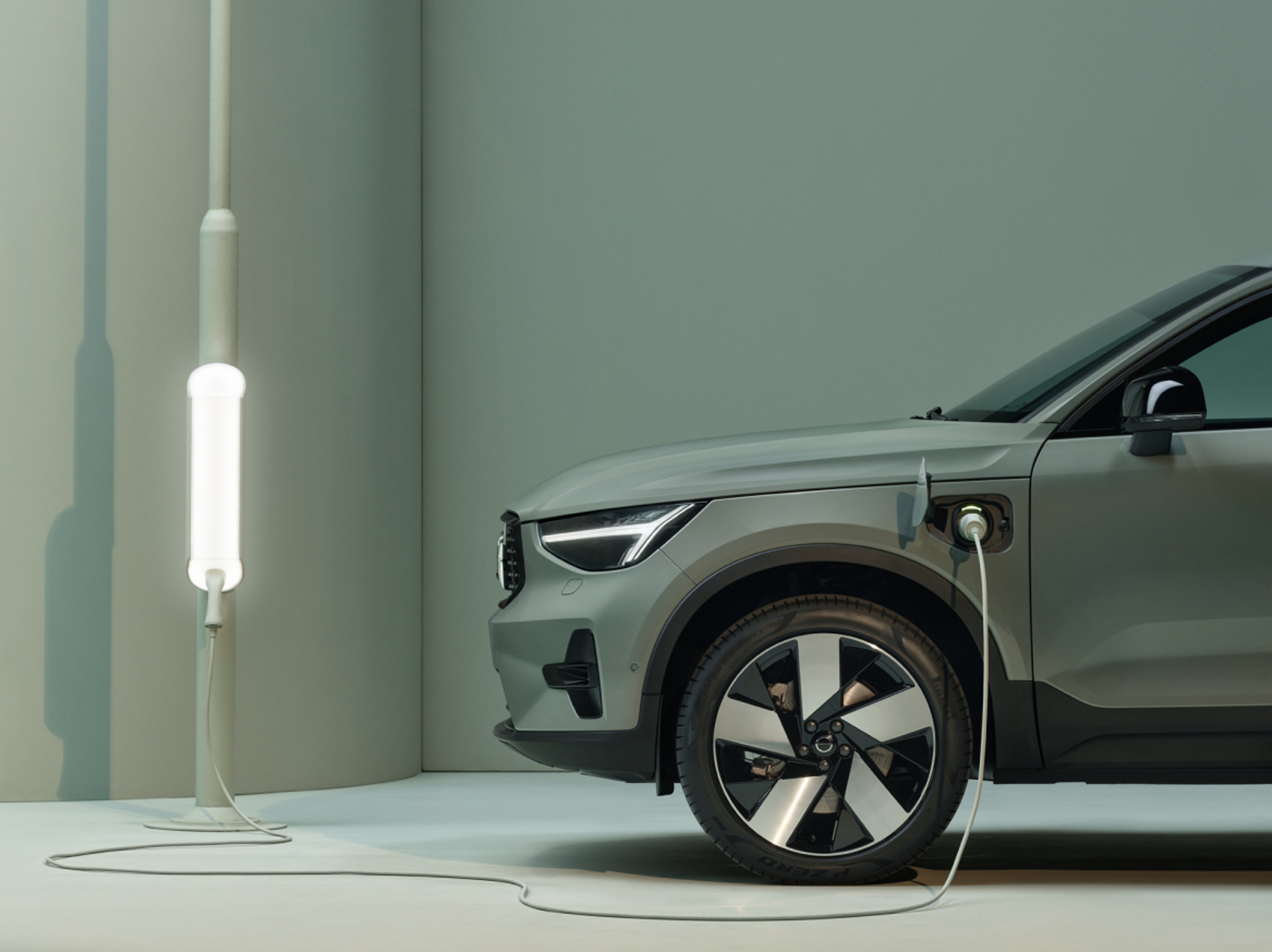 A close-up of a charging cable plugged into the charging port of a Volvo Recharge car.