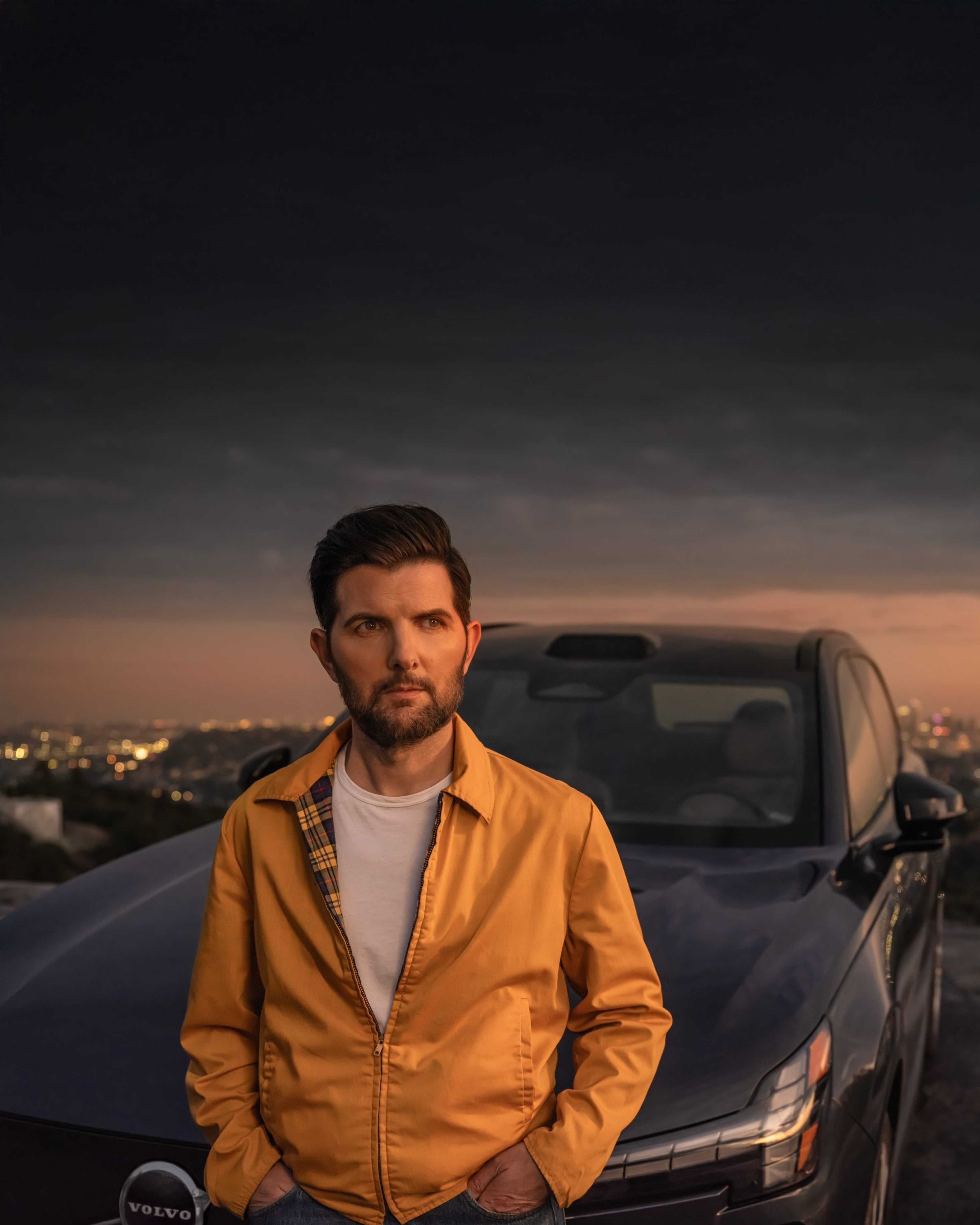 Volvo Stories - Adam Scott standing in front of a Volvo EX90 electric SUV