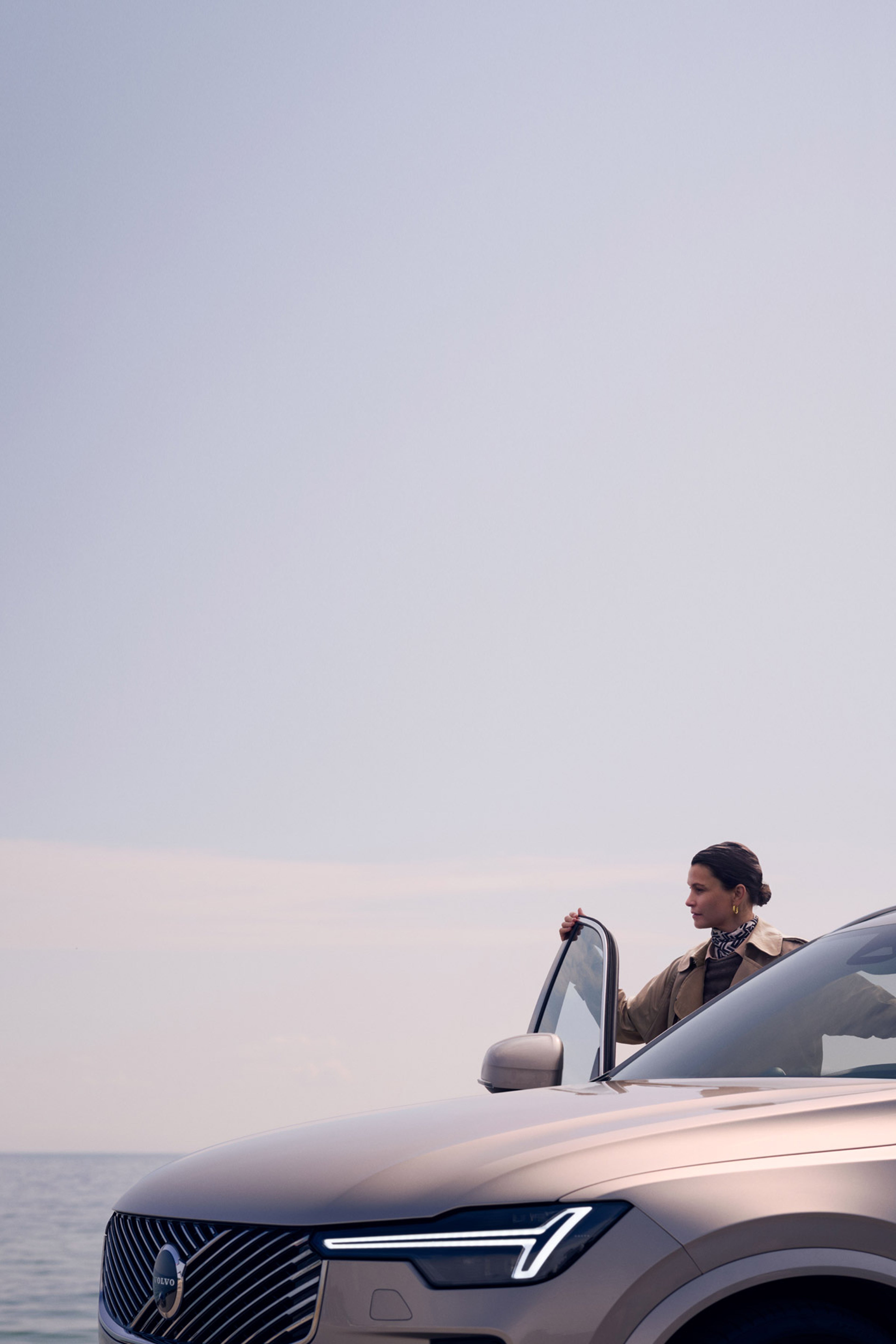 Ženska stoji ob odprtih vratih Volva