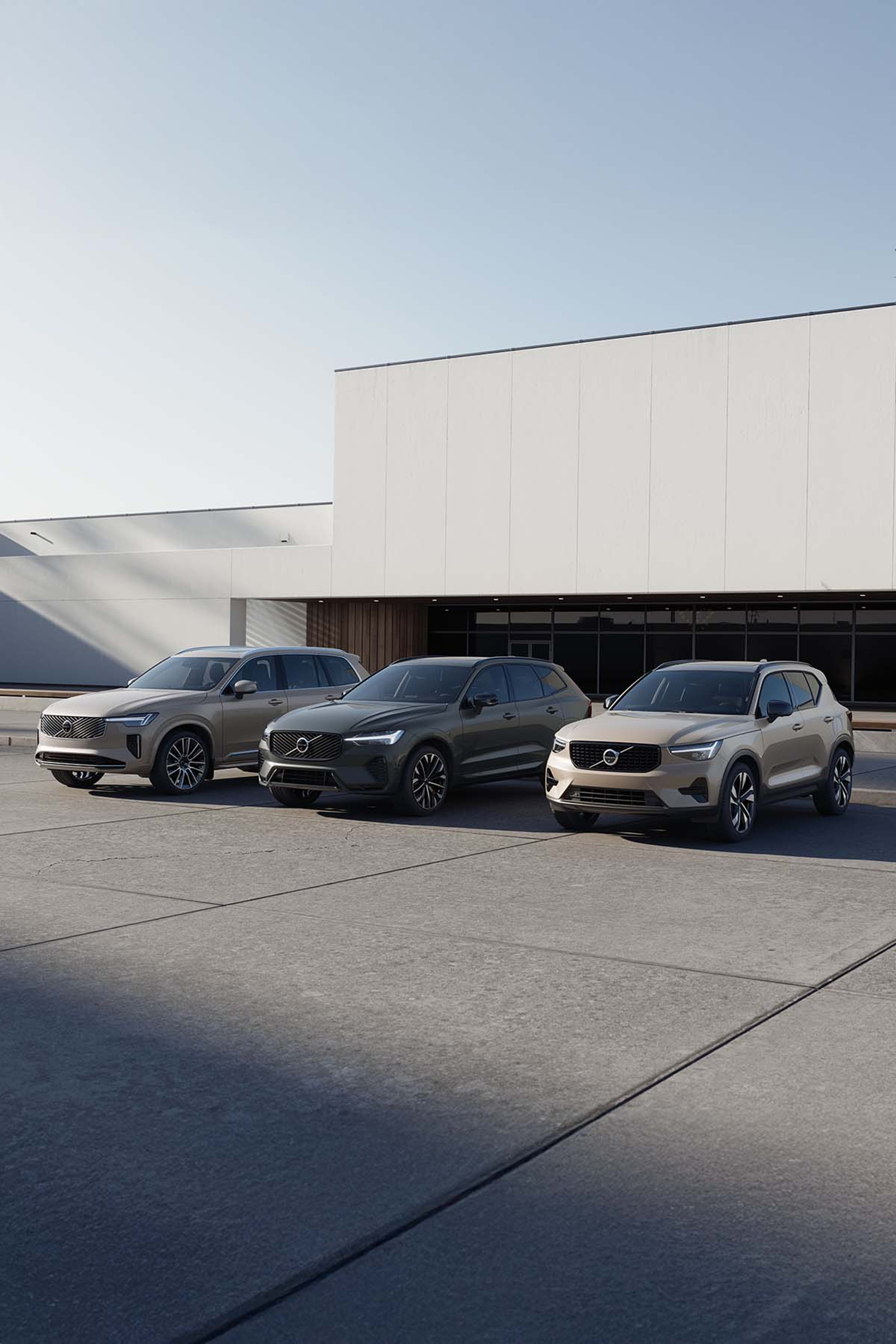 Volvo XC90, Volvo XC60 i Volvo XC40 parkirani ispred poslovne zgrade.