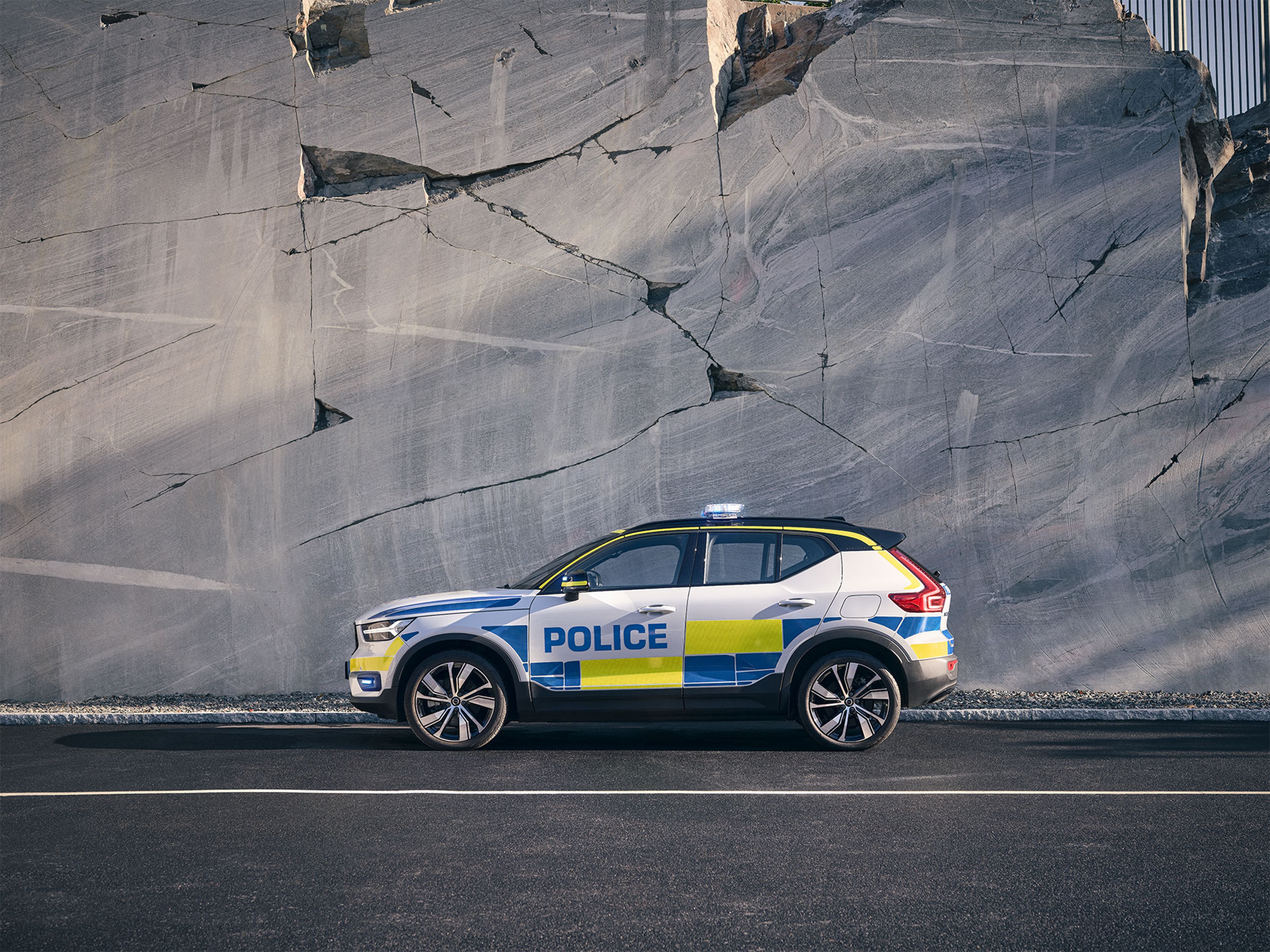 De volledig elektrische XC40 politieauto gezien vanaf de zijkant op een parkeerplaats.