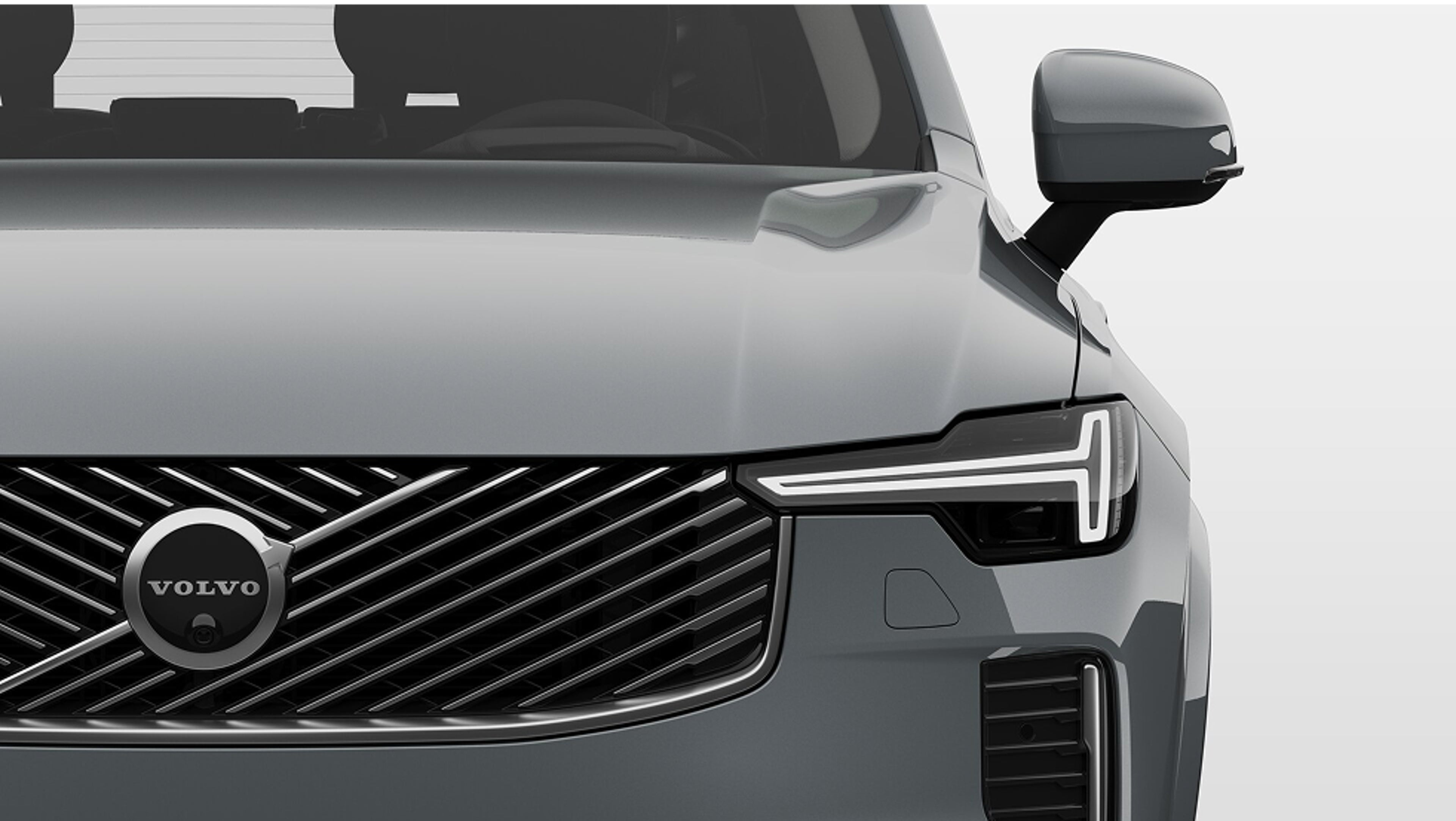 Čelní pohled zblízka na plug-in hybridní Volvo s ocelovou maskou chladiče a elegantními světlomety