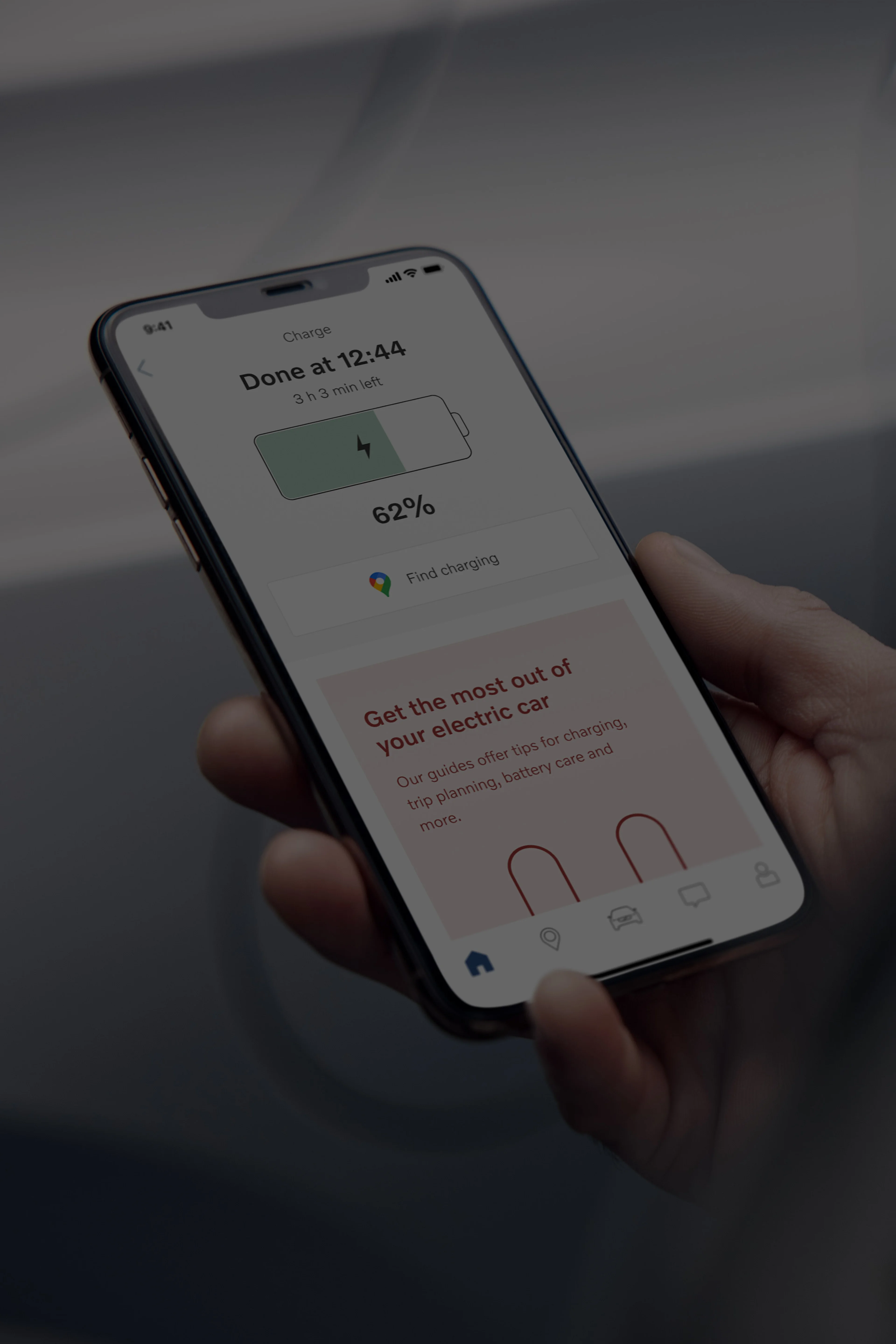 Volvo Cars app avtomobilindəki akkumulyatorun doldurulması vəziyyətinə baxan Volvo avtomobili sahibinin çiyin üzərindən görünüşü.
