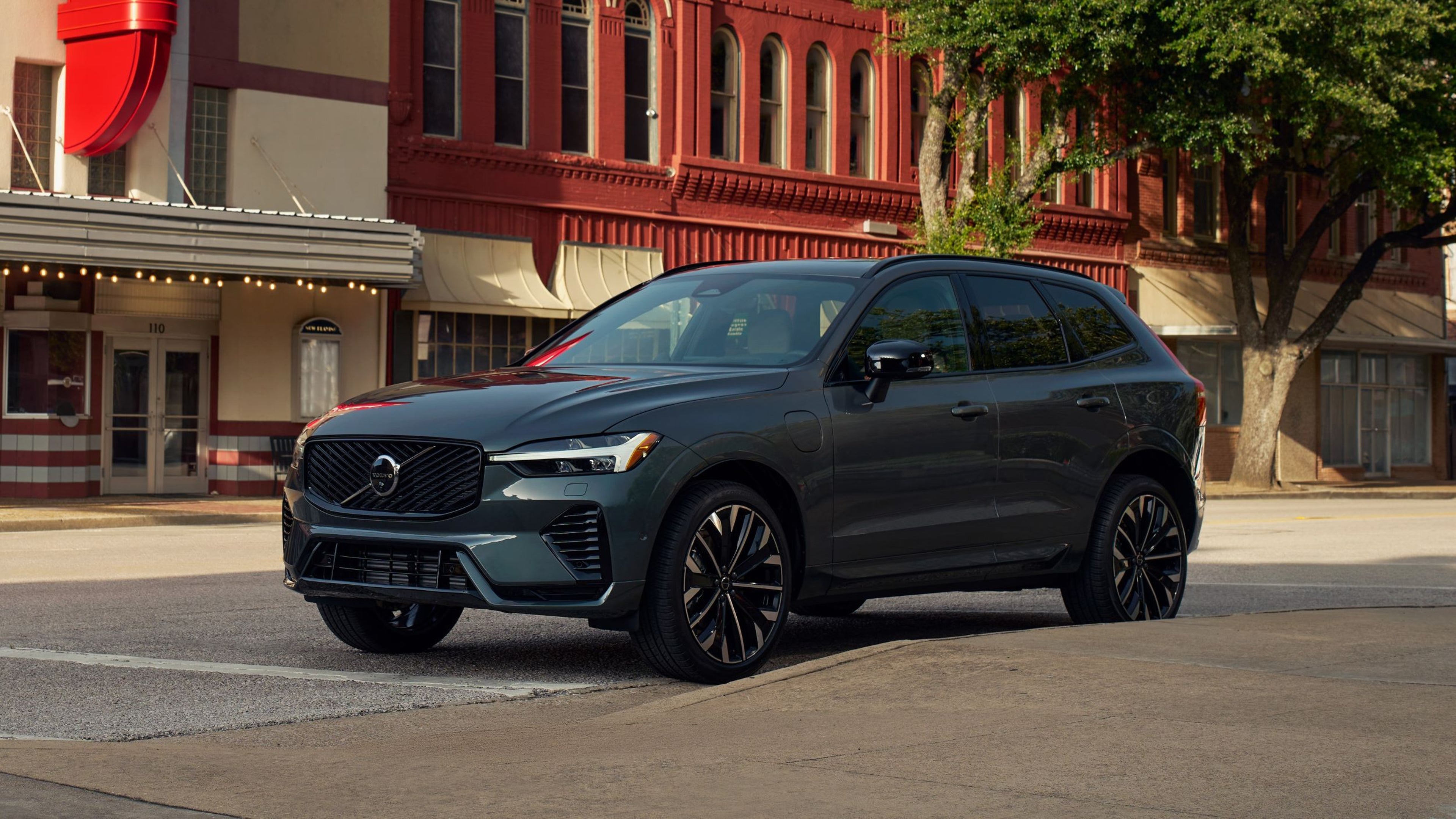 Volvo XC60 parked on city street with tree in background