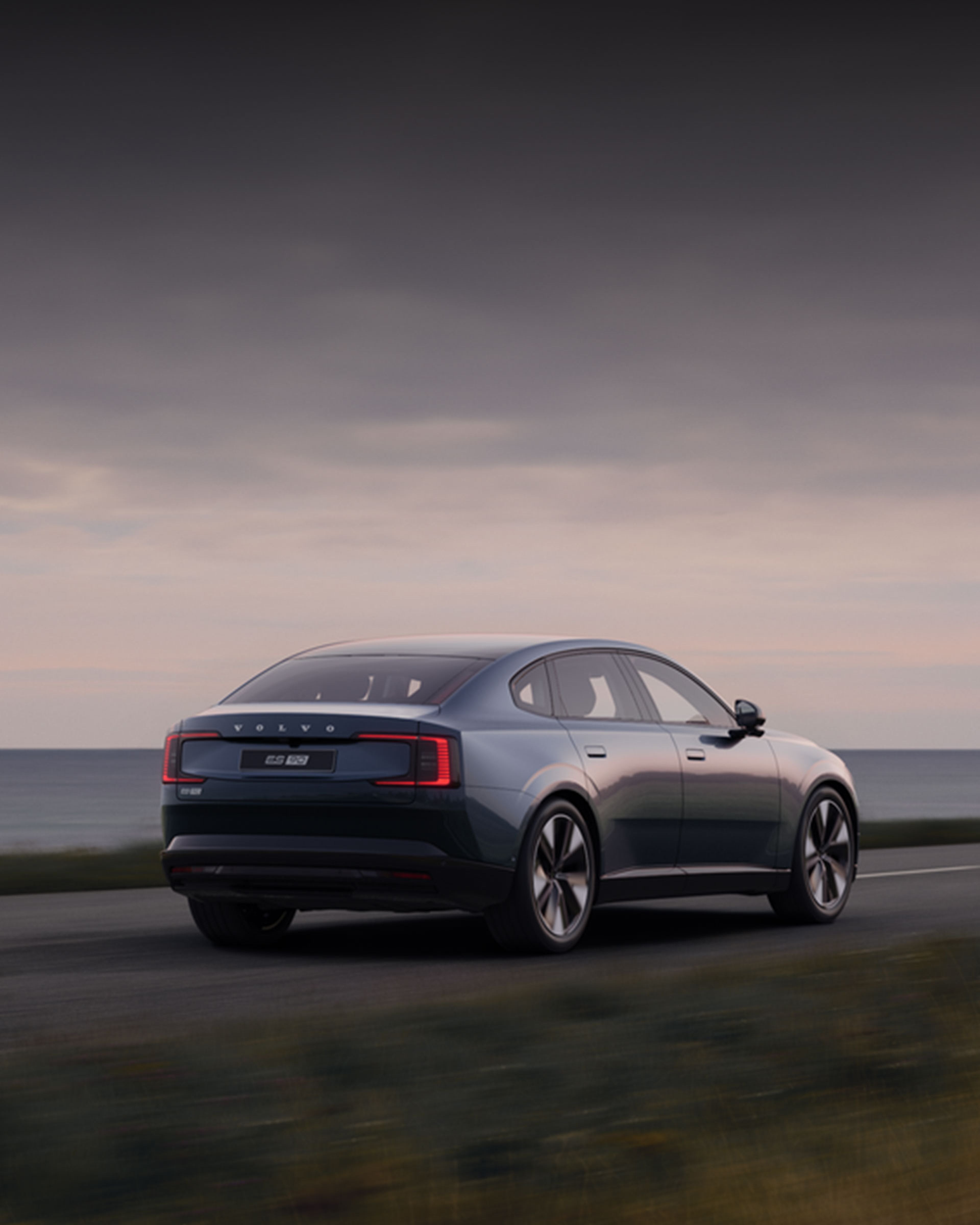 Vue 3/4 arrière d'une ES90 bleu Denim sur une route côtière