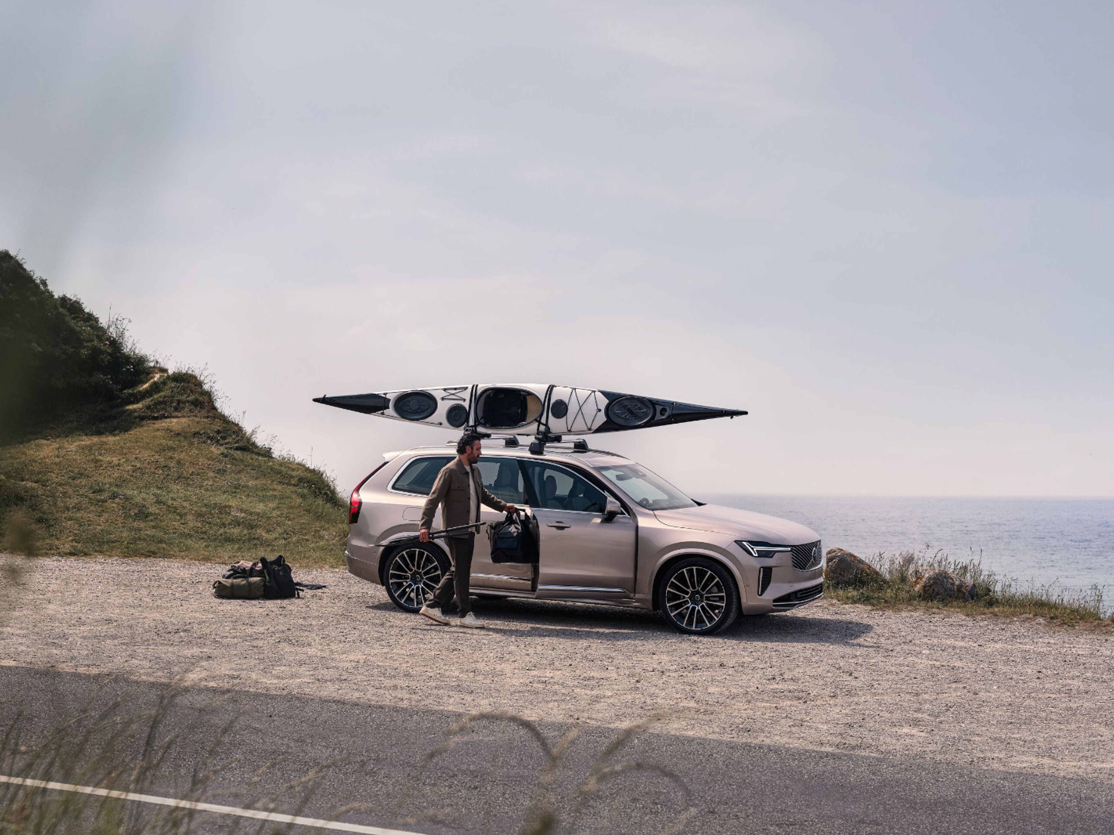 Eine verschwommene Frau steht in der Mitte einer Strasse. Hinter ihr ist ein Volvo EX90 sichtbar.