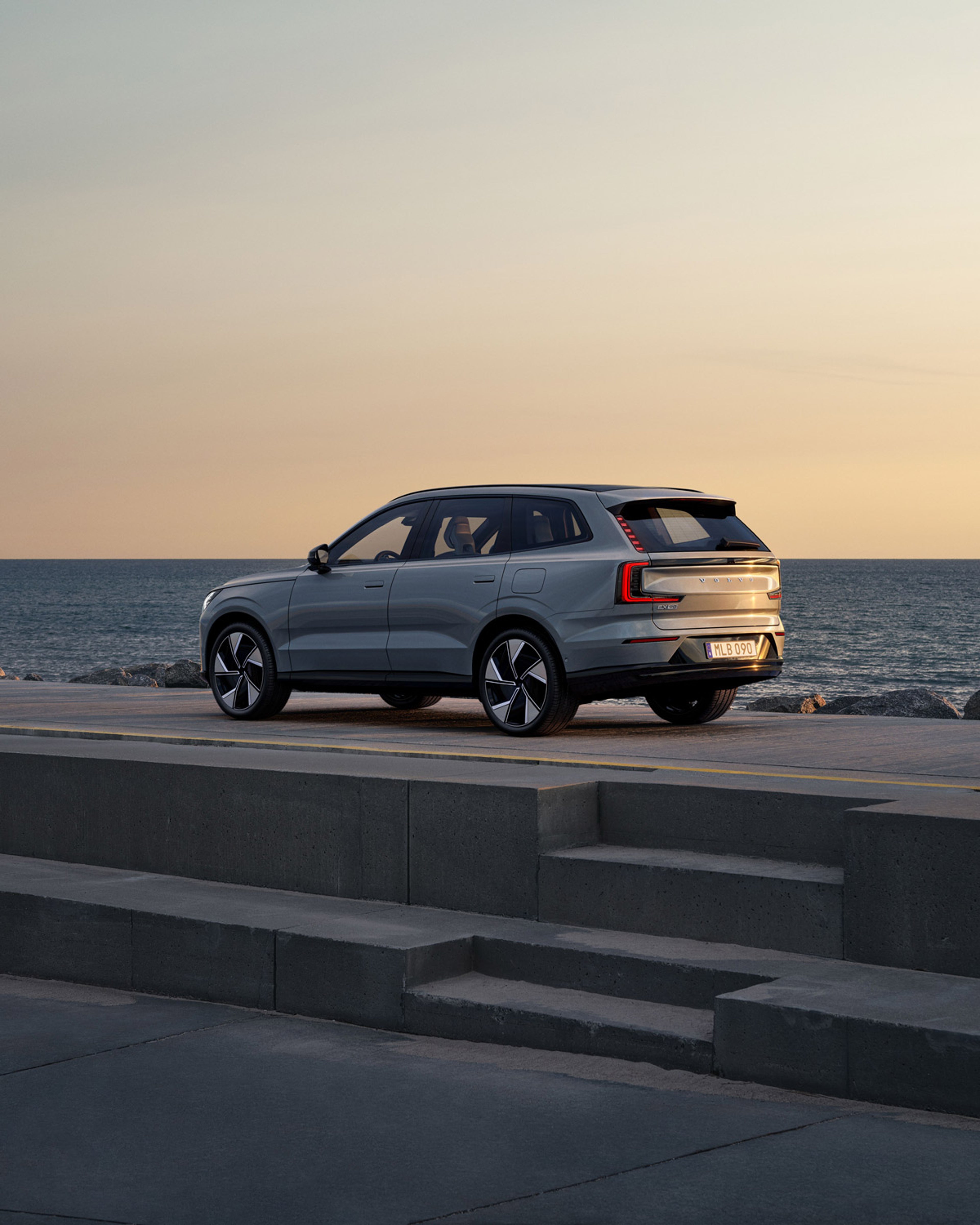 Volvo EX90 parkerad på gata vid havet i skymningsljus