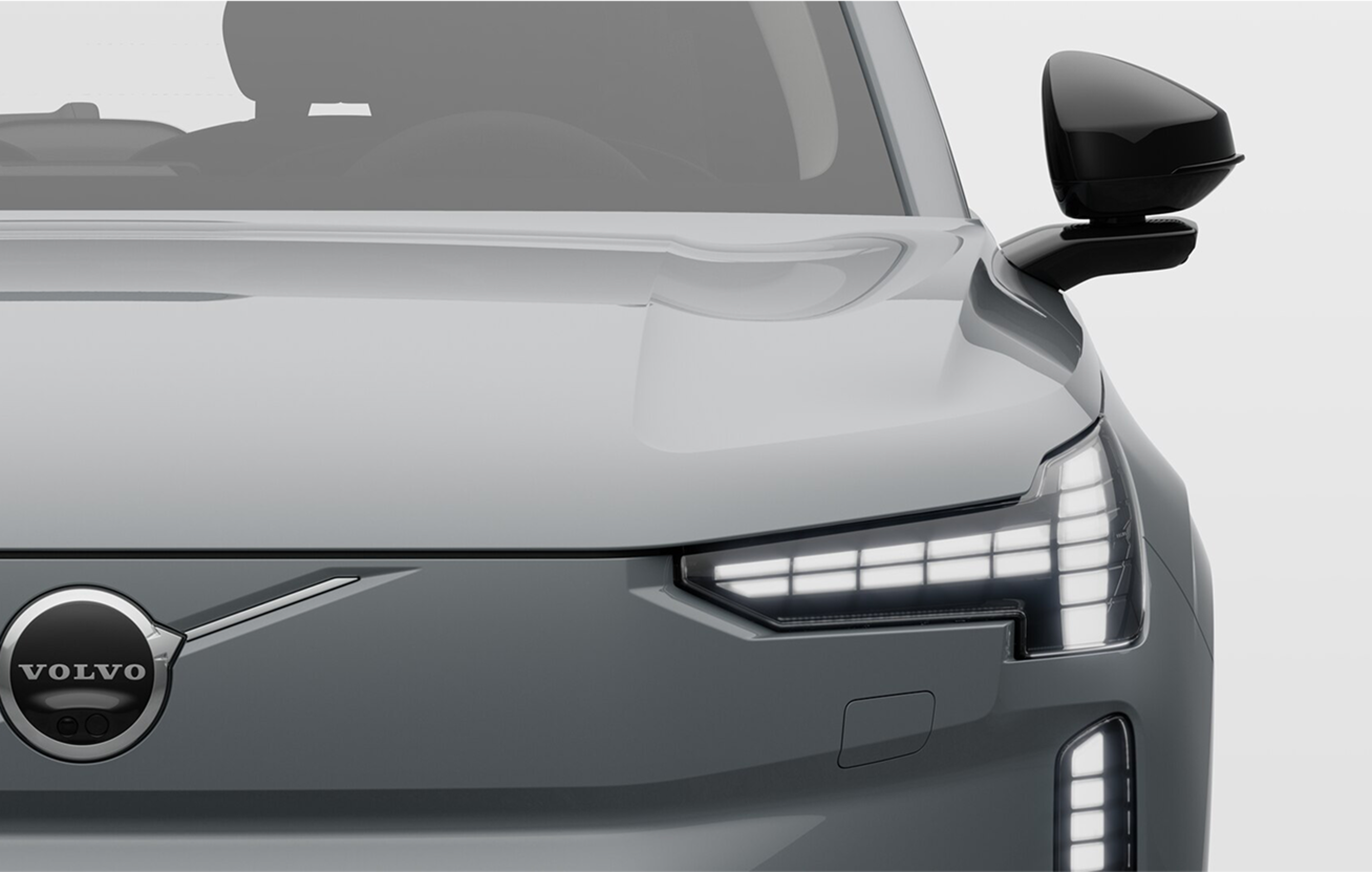 Pilnībā elektriskās Volvo automašīnas ar
ieslēgtiem priekšējiem lukturiem priekšpuses skats.