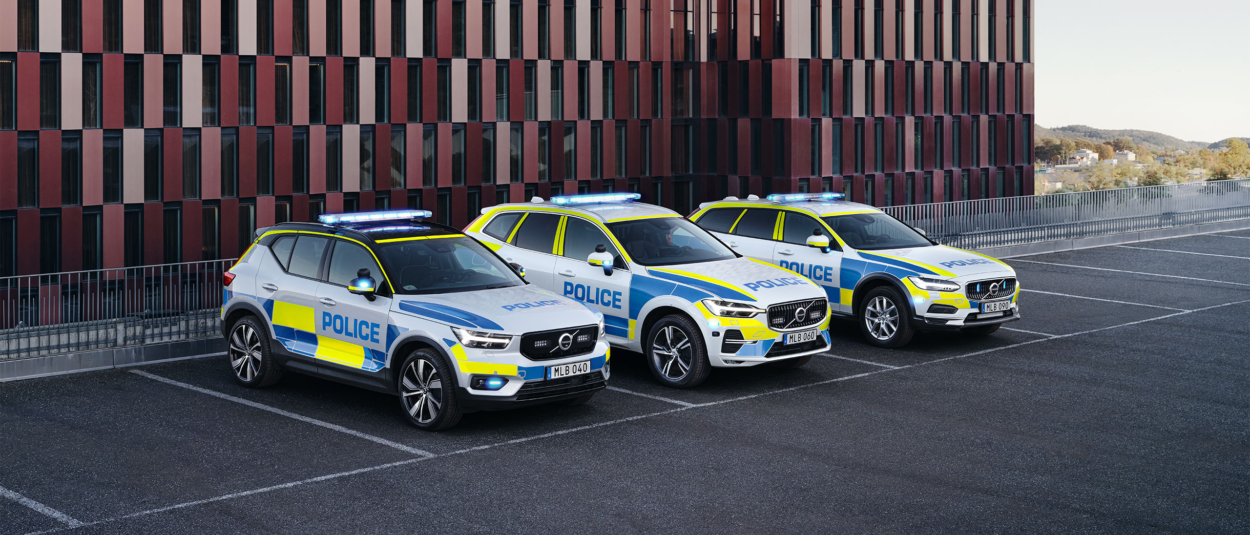 Elbilen Volvo XC40, XC60 och V90 Cross Country i polisbilsutförande parkerade utanför en officiell byggnad.