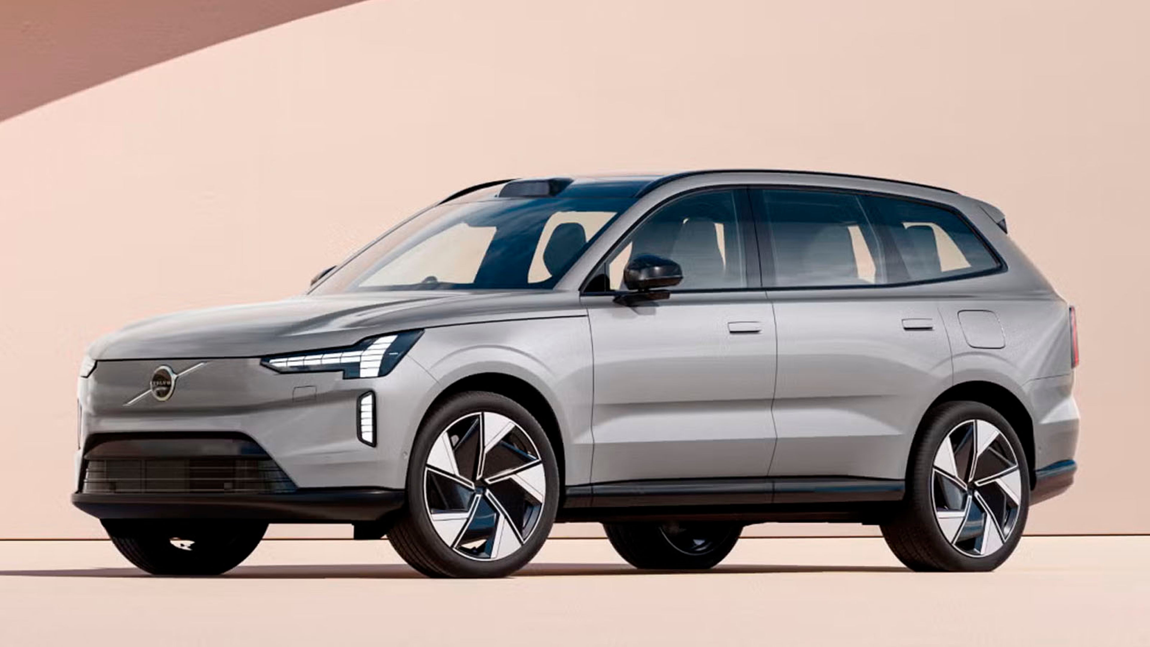 Volvo EX90 en un patio bajo la luz del sol en una vista lateral destacando sus líneas aerodinámicas.