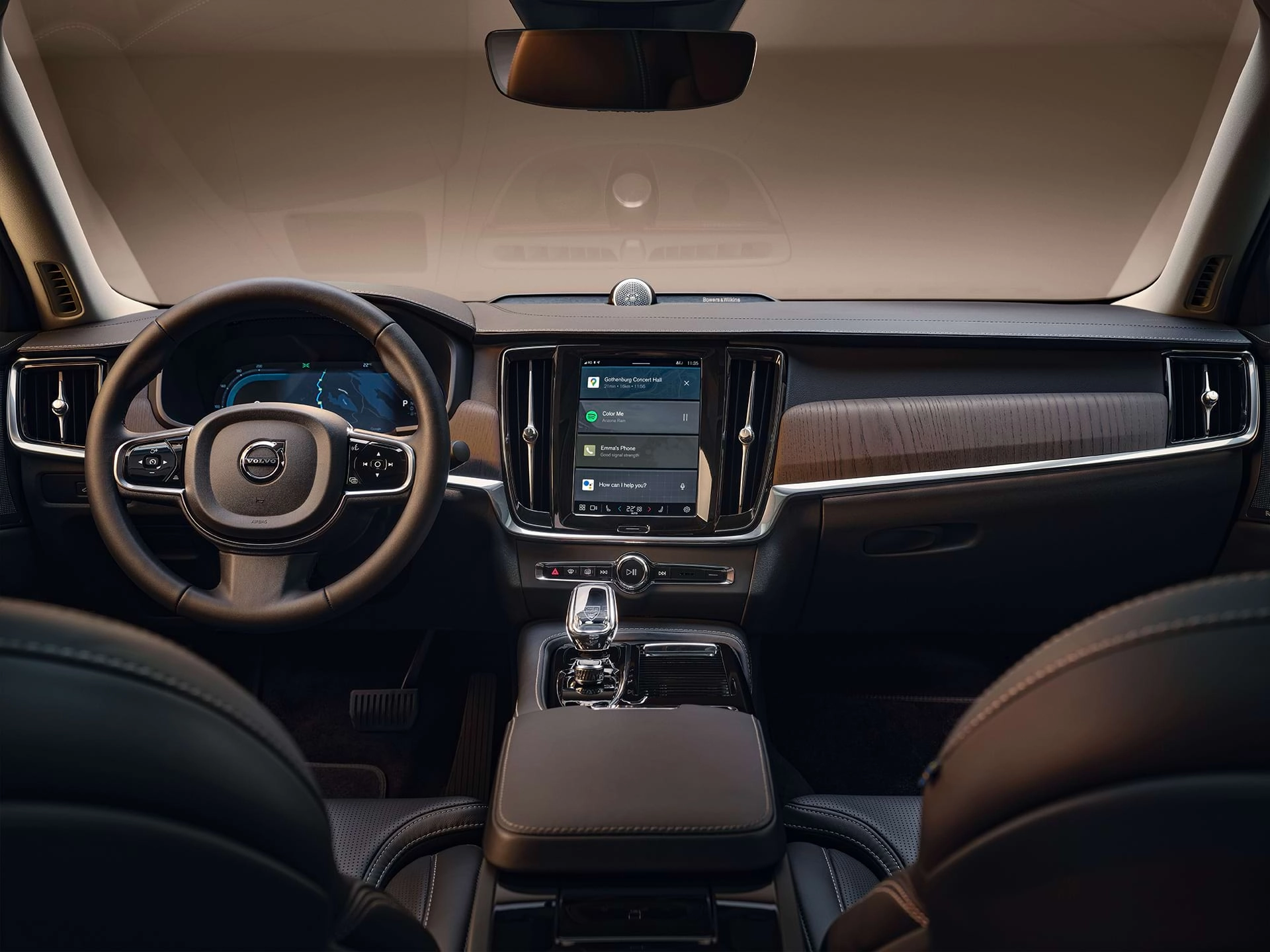El tablero, la pantalla central, la palanca de cambios, la pantalla del conductor y el volante de un automóvil sedán Volvo.
