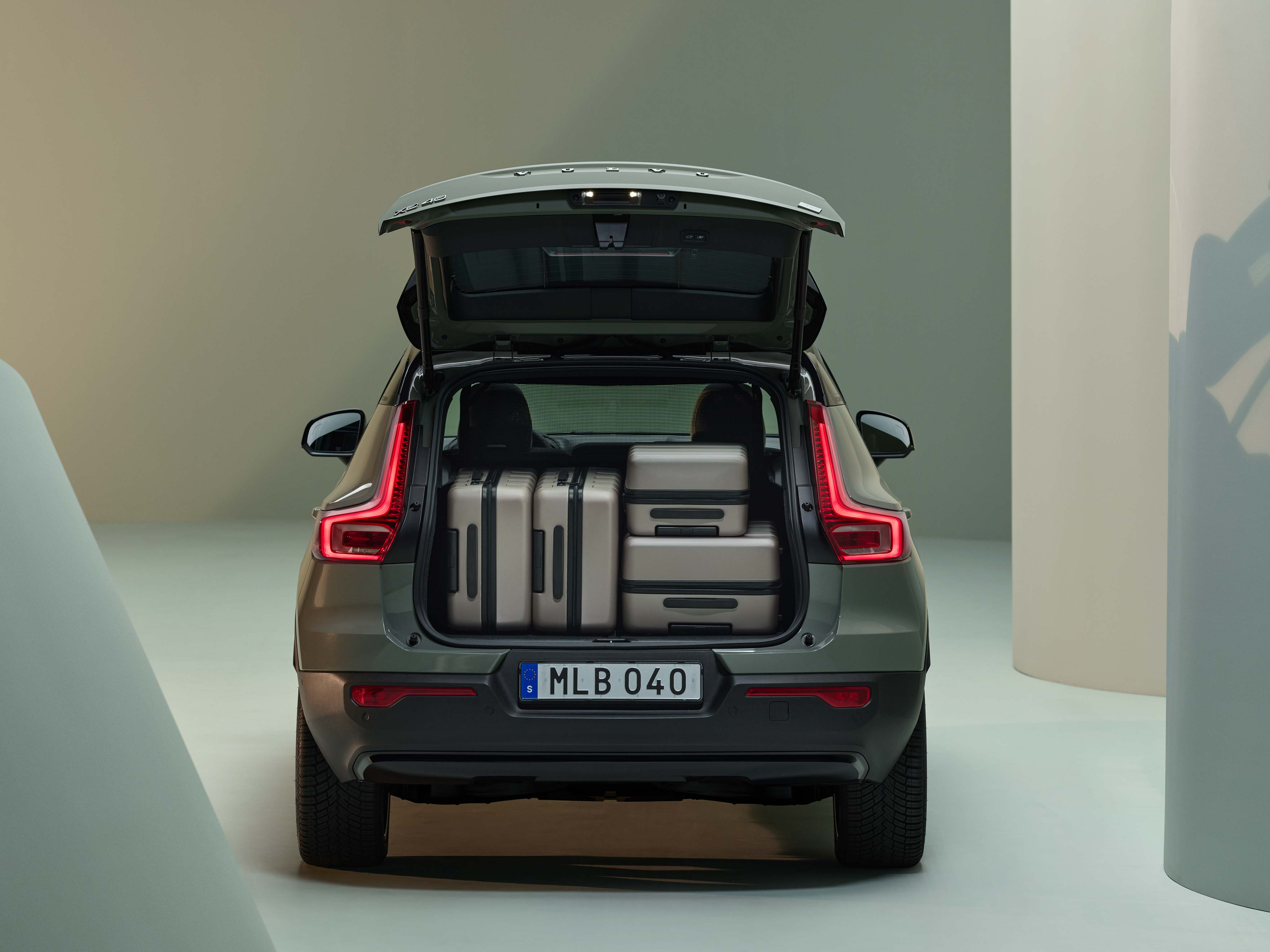 Bagfra ses et stort bagagerum i en Volvo SUV med flere store kasser.