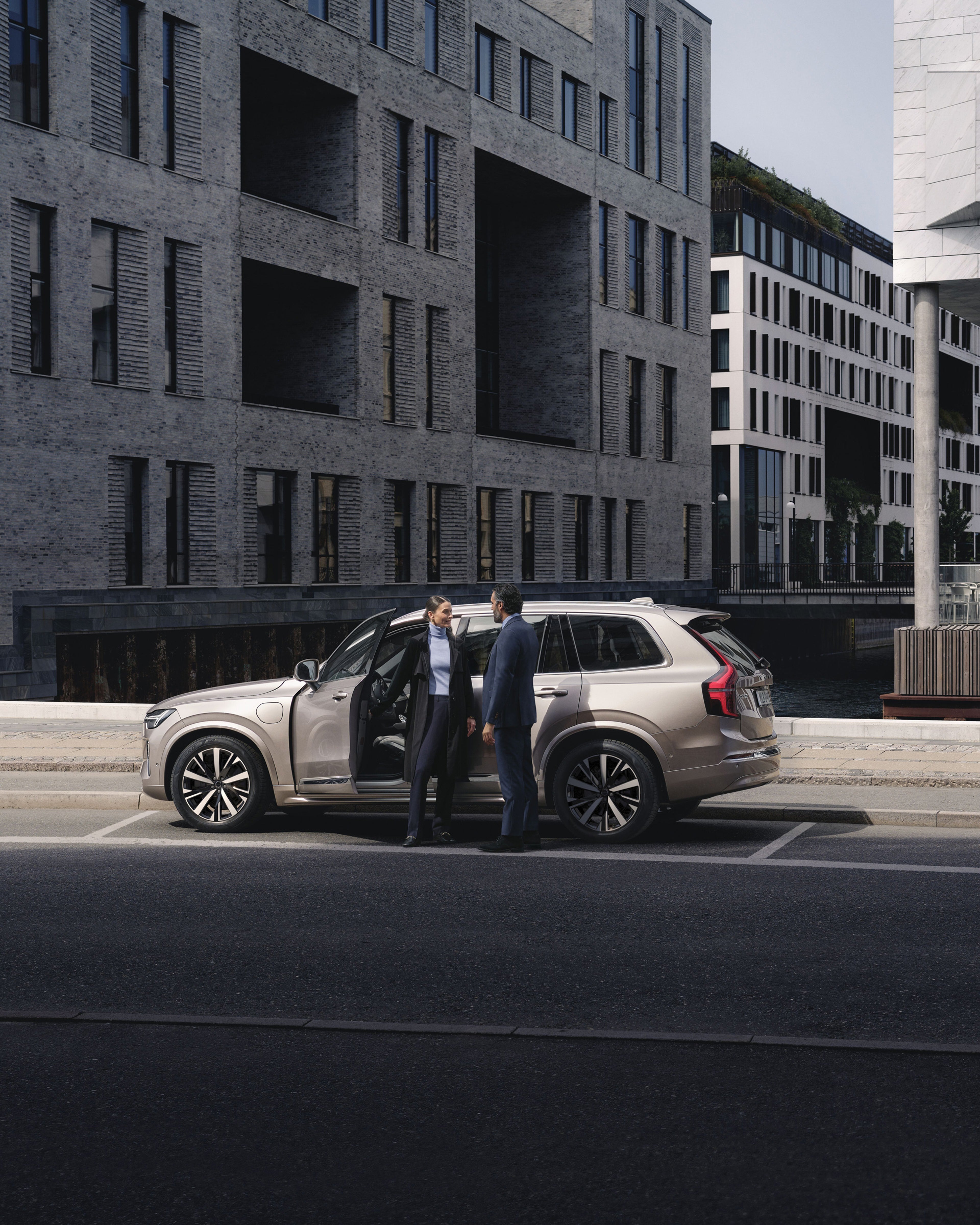 Vista aerea di un uomo che lascia la sua Volvo S90 parcheggiata accanto a scale di marmo con motivi grafici.