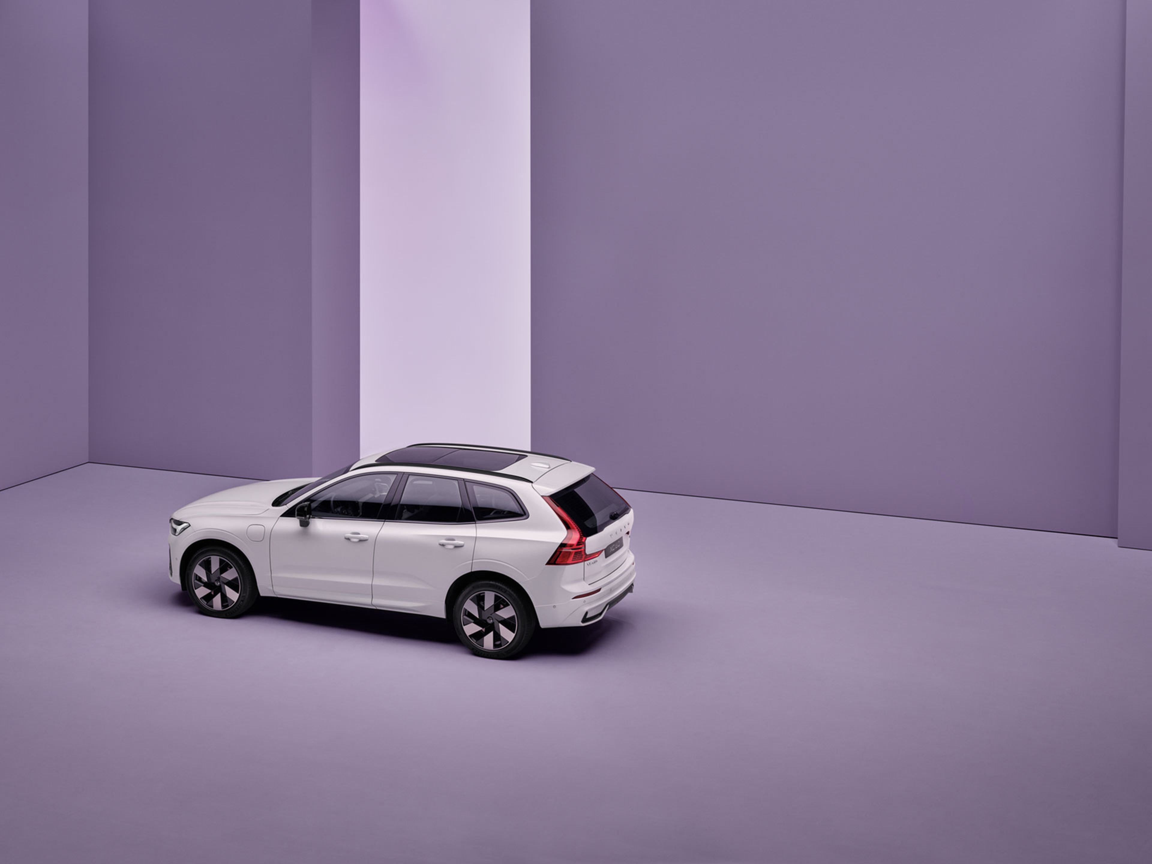 Vista a larga distancia de un Volvo XC60 híbrido enchufable estacionado en un espacio interior abierto y vacío.