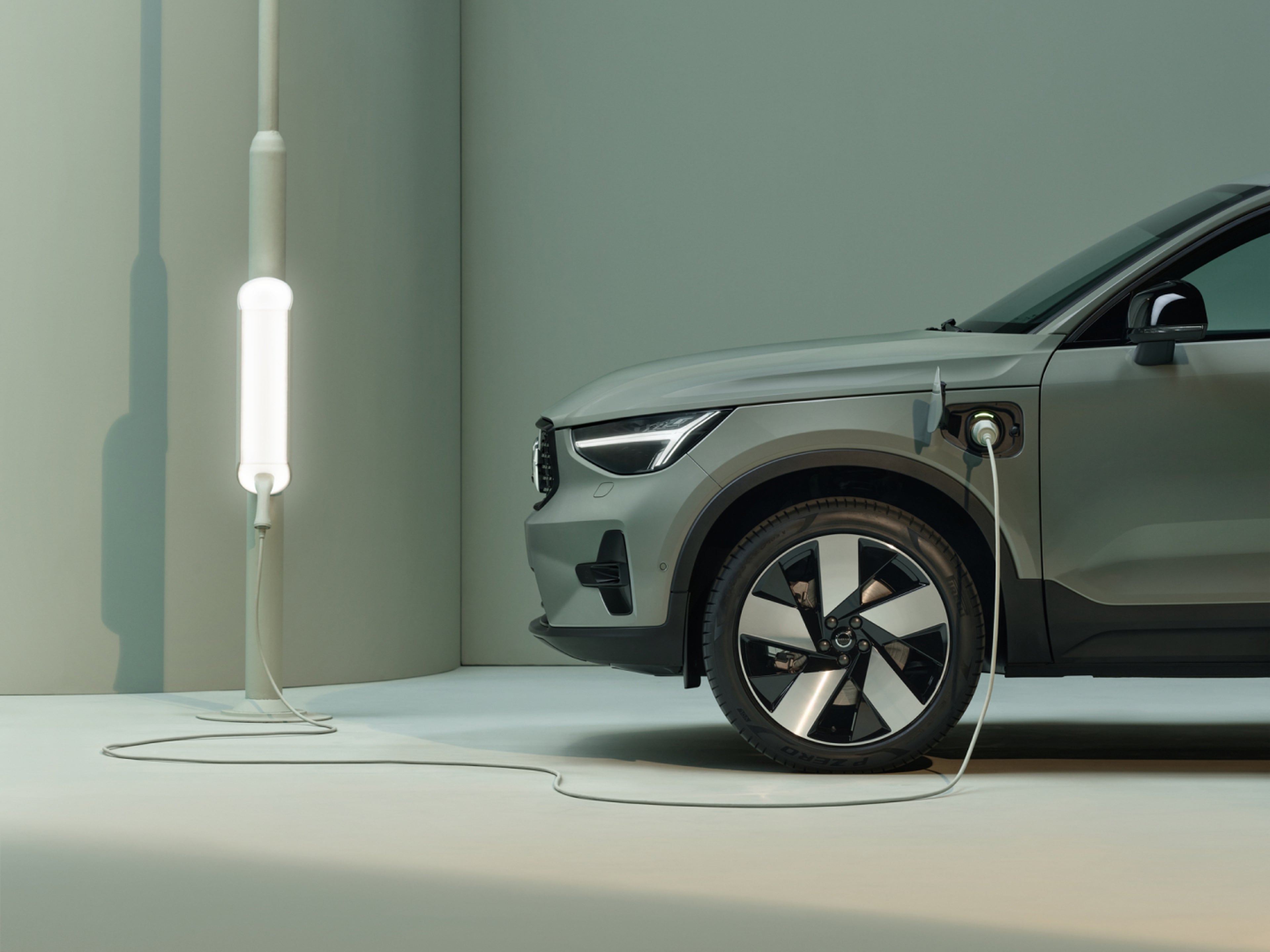 Primer plano de un cable de carga conectado al puerto de un coche Volvo Recharge.