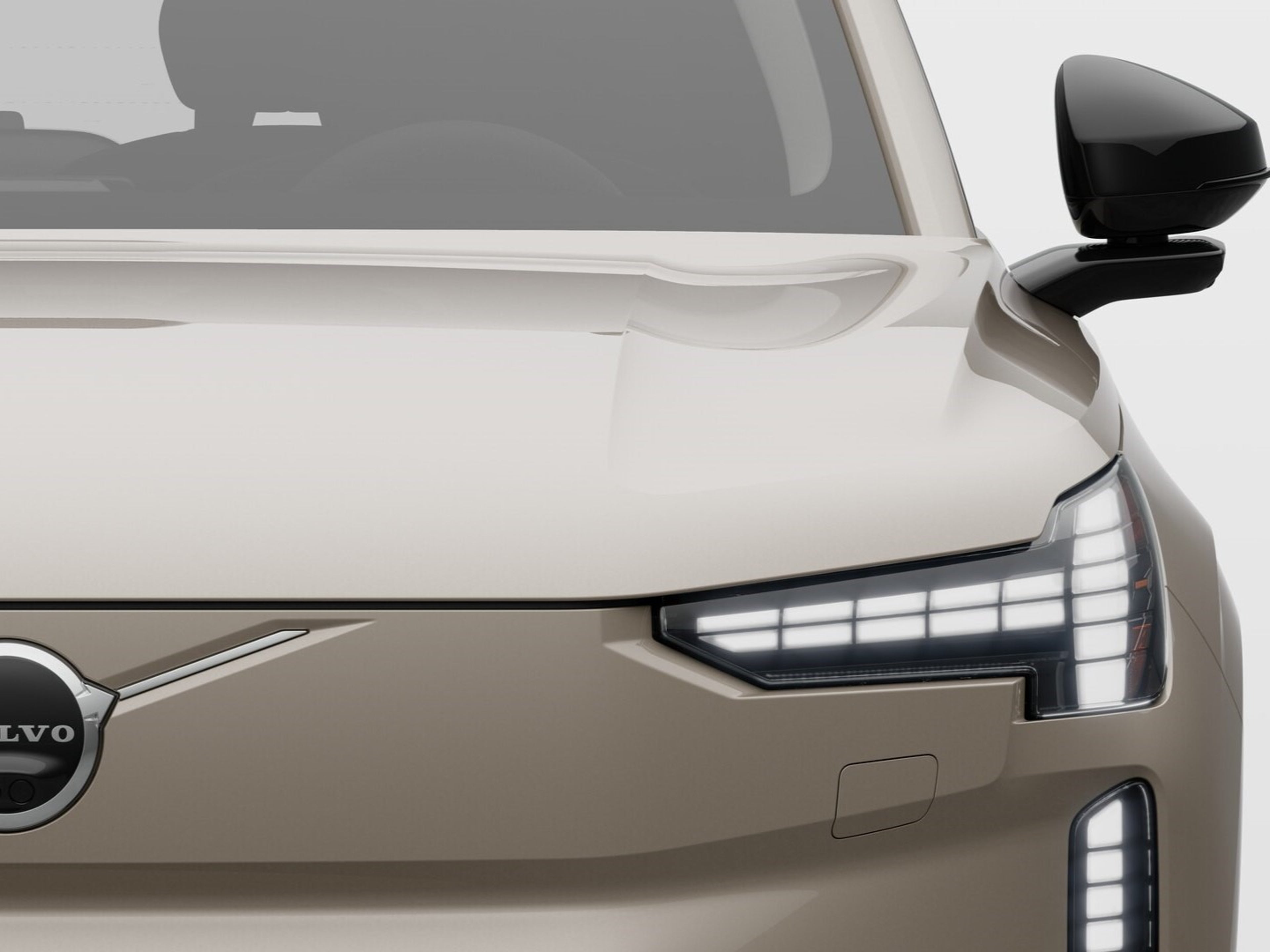 Front close up view of a fully electric Volvo car with 
the headlights on.