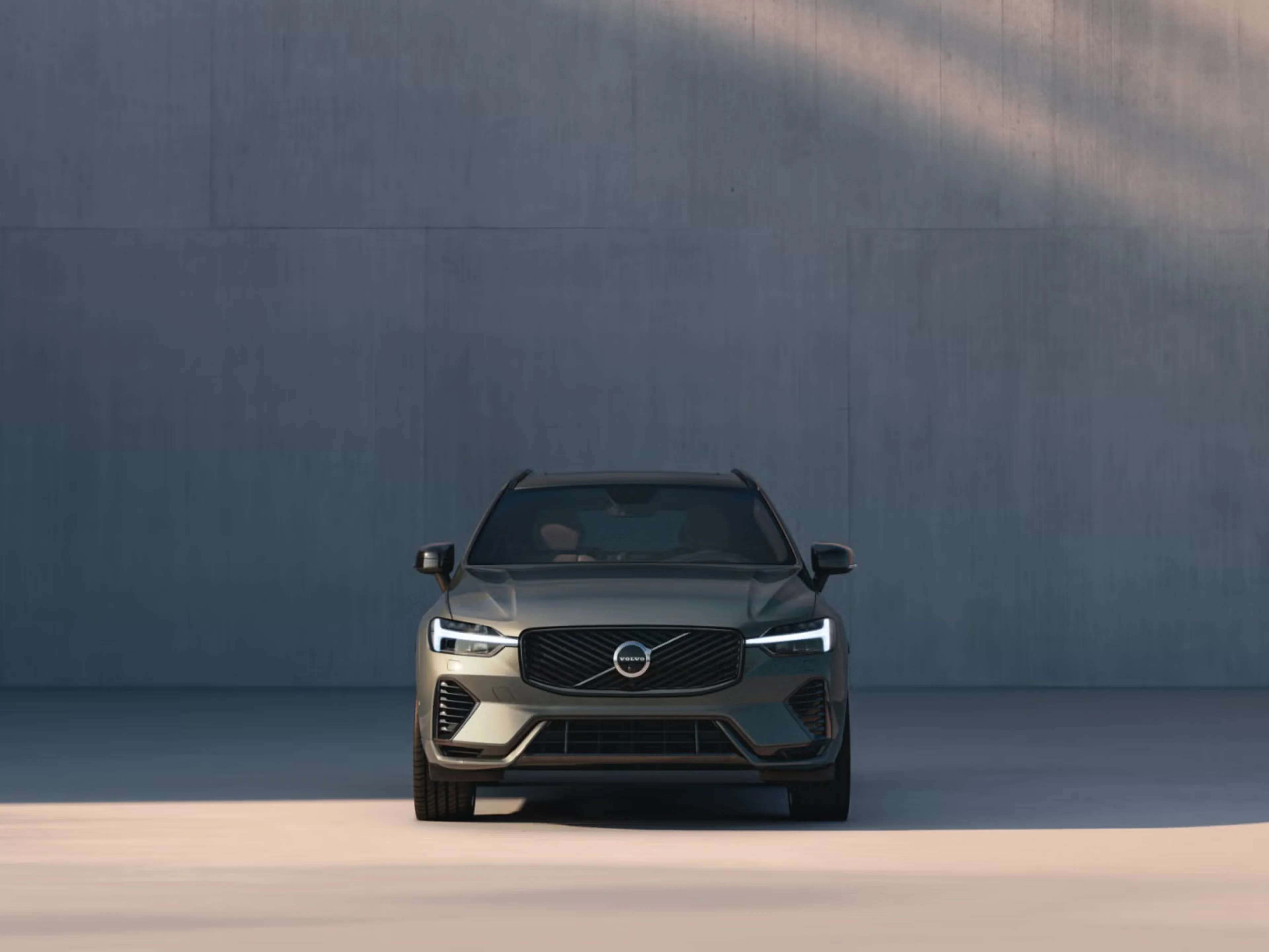Front view of XC60 in front of shadowy concrete wall