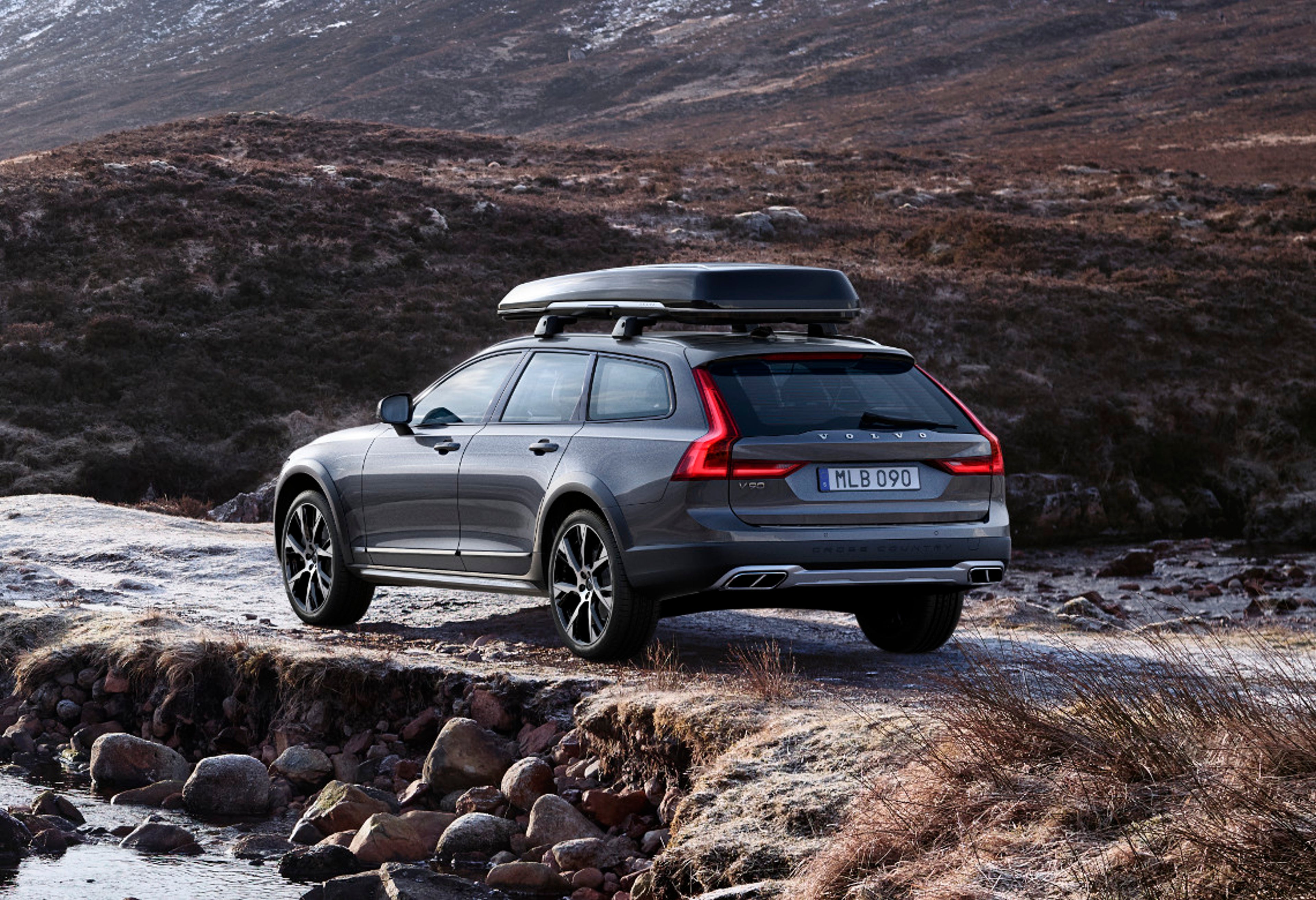 Volvo V90 CROSS COUNTRY mit Dachbox steht am Meer