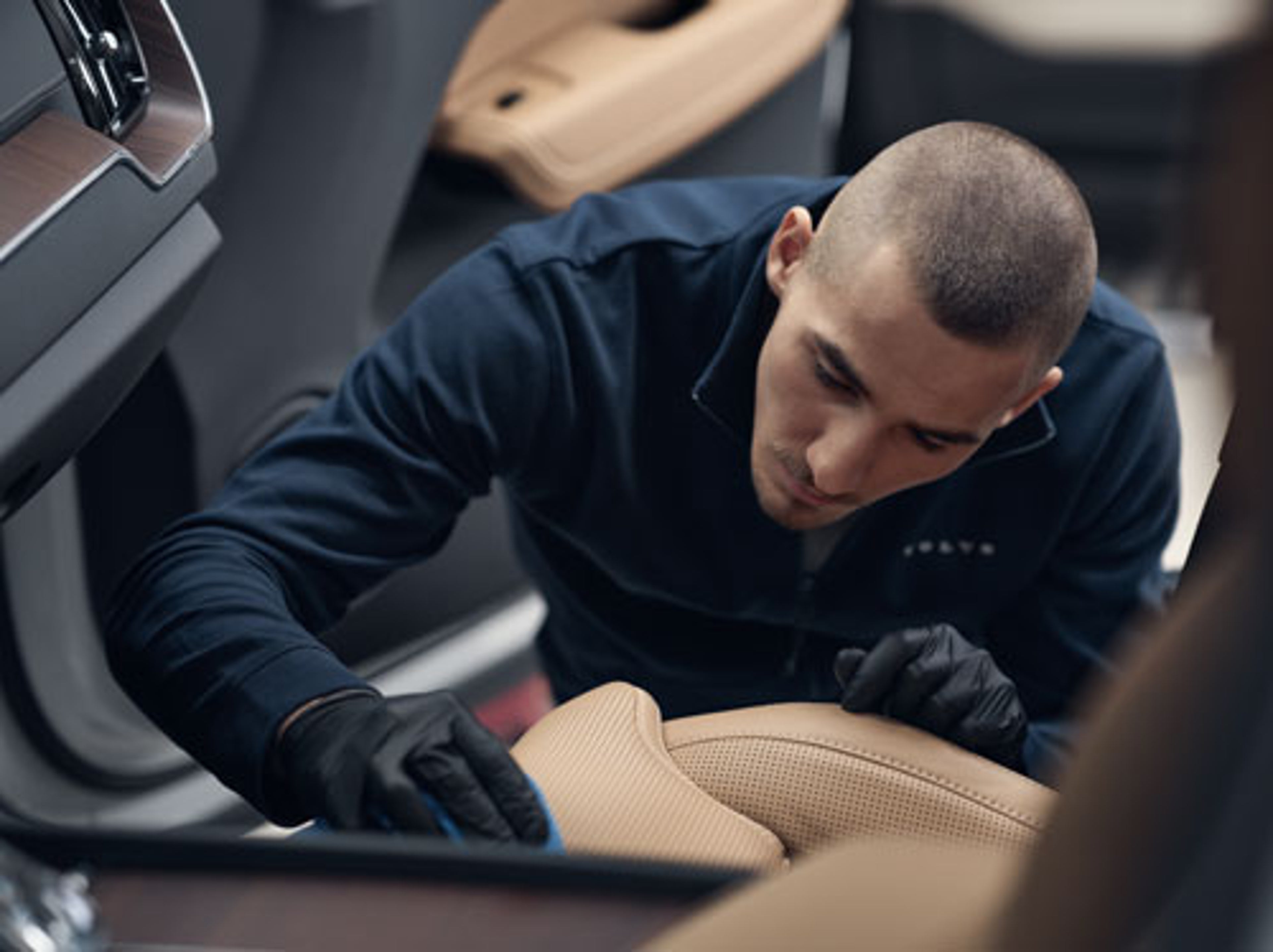 Volvo tekniker som renser skinnseter