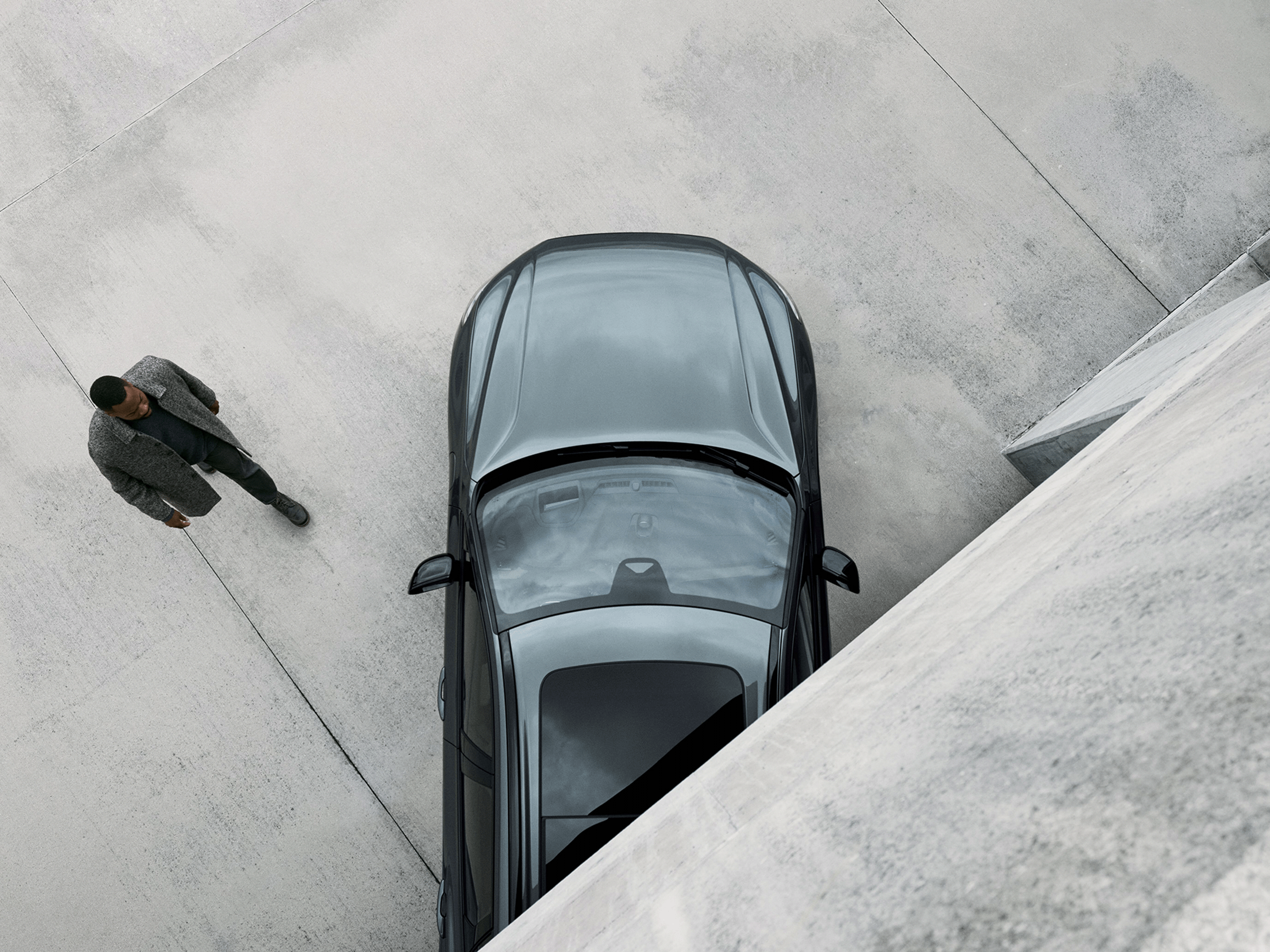 Ein Mann läuft auf einen Volvo XC60 zu.