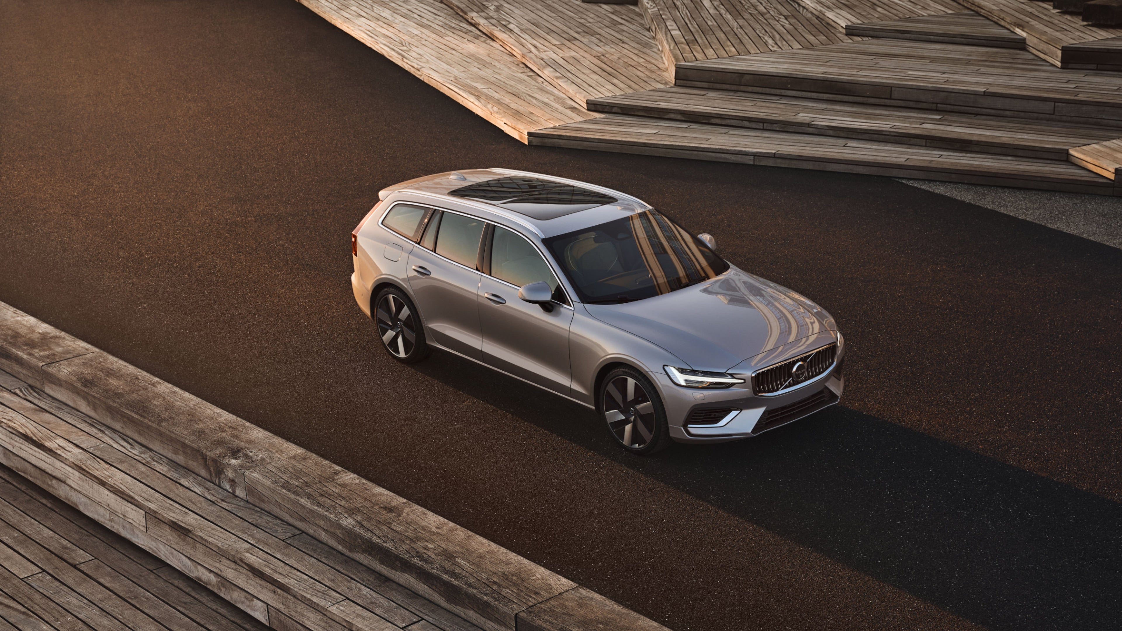 Ein seitlich geparkter silberner Volvo V60 steht auf einer braunen Plattform
