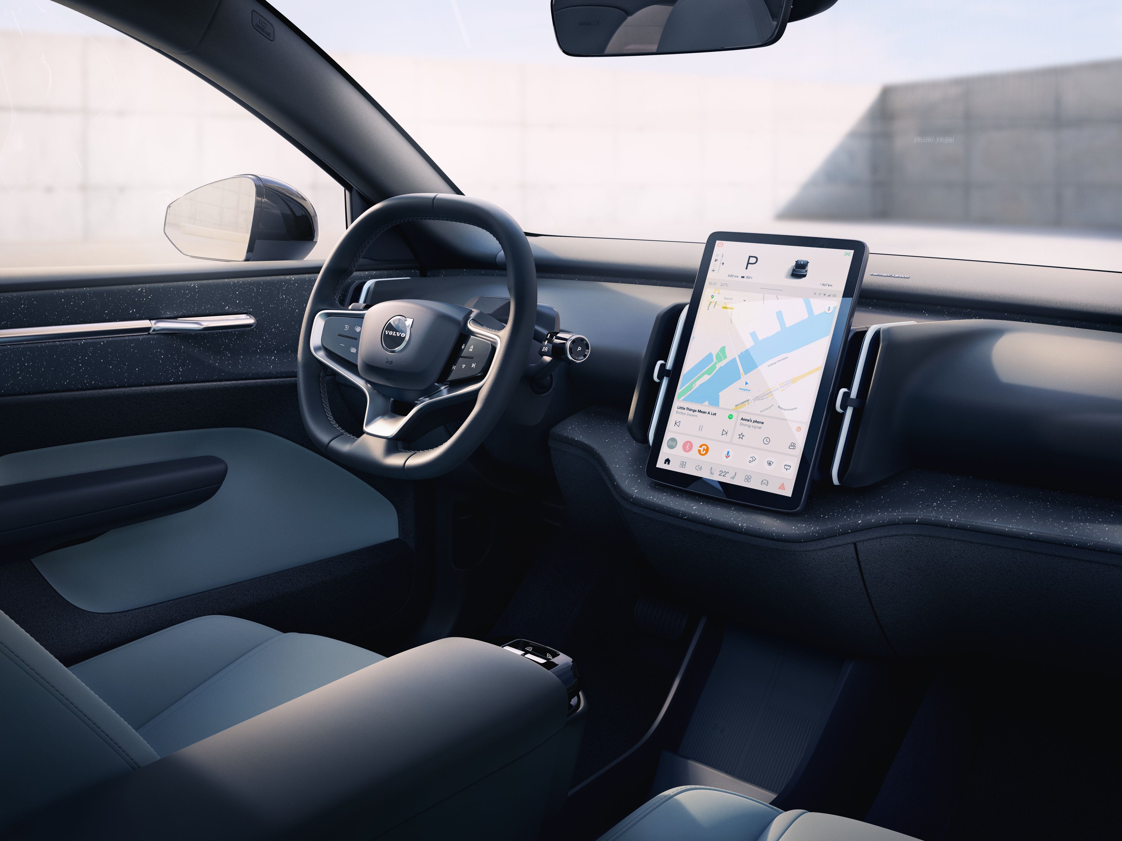 Intérieur d’une voiture Volvo EX30 avec volant et écran tactile affichant une carte de navigation.