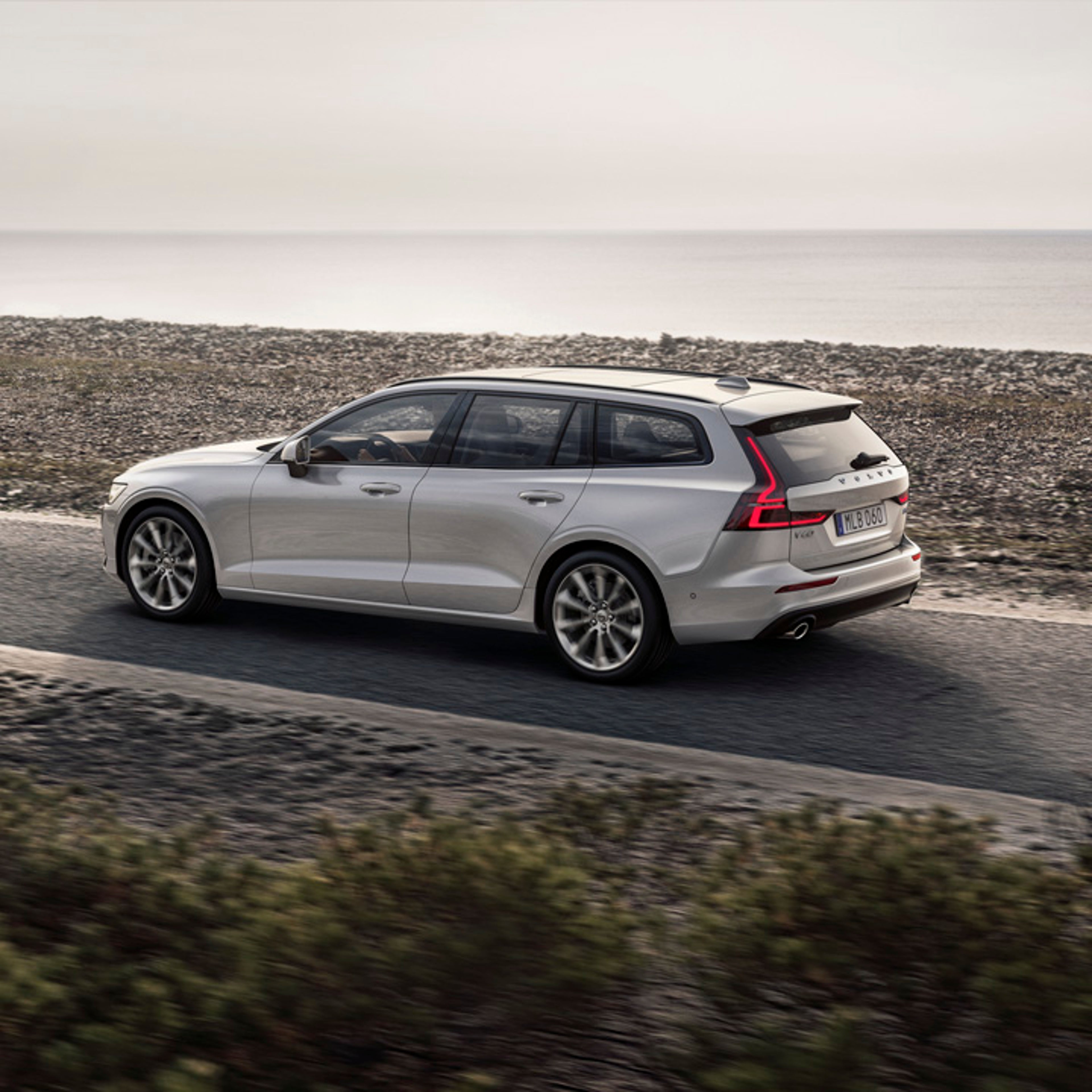 Volvo V60 blanco en una carretera junto al mar