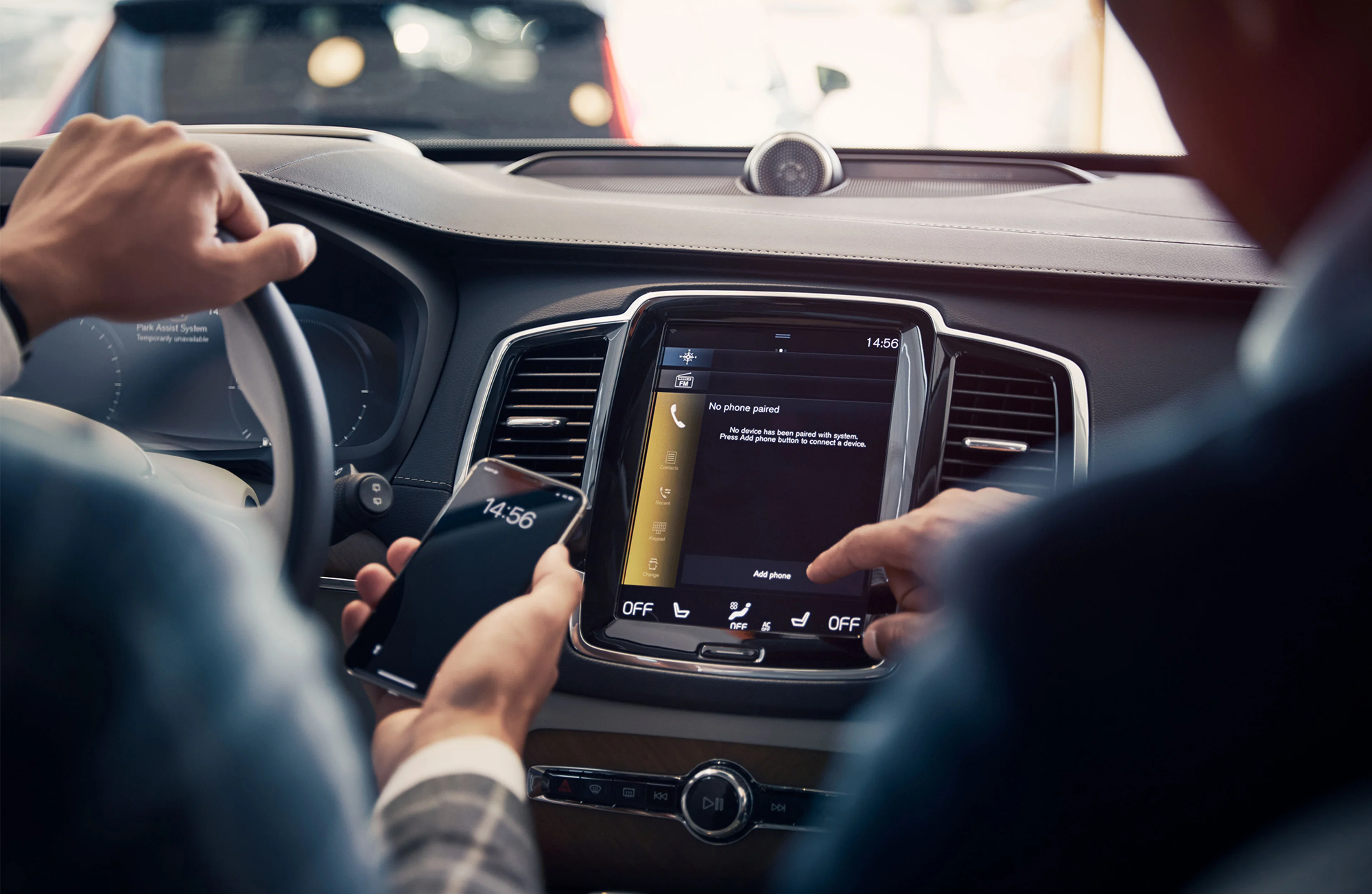 To personer i en bil sett bakfra som peker på en mobil