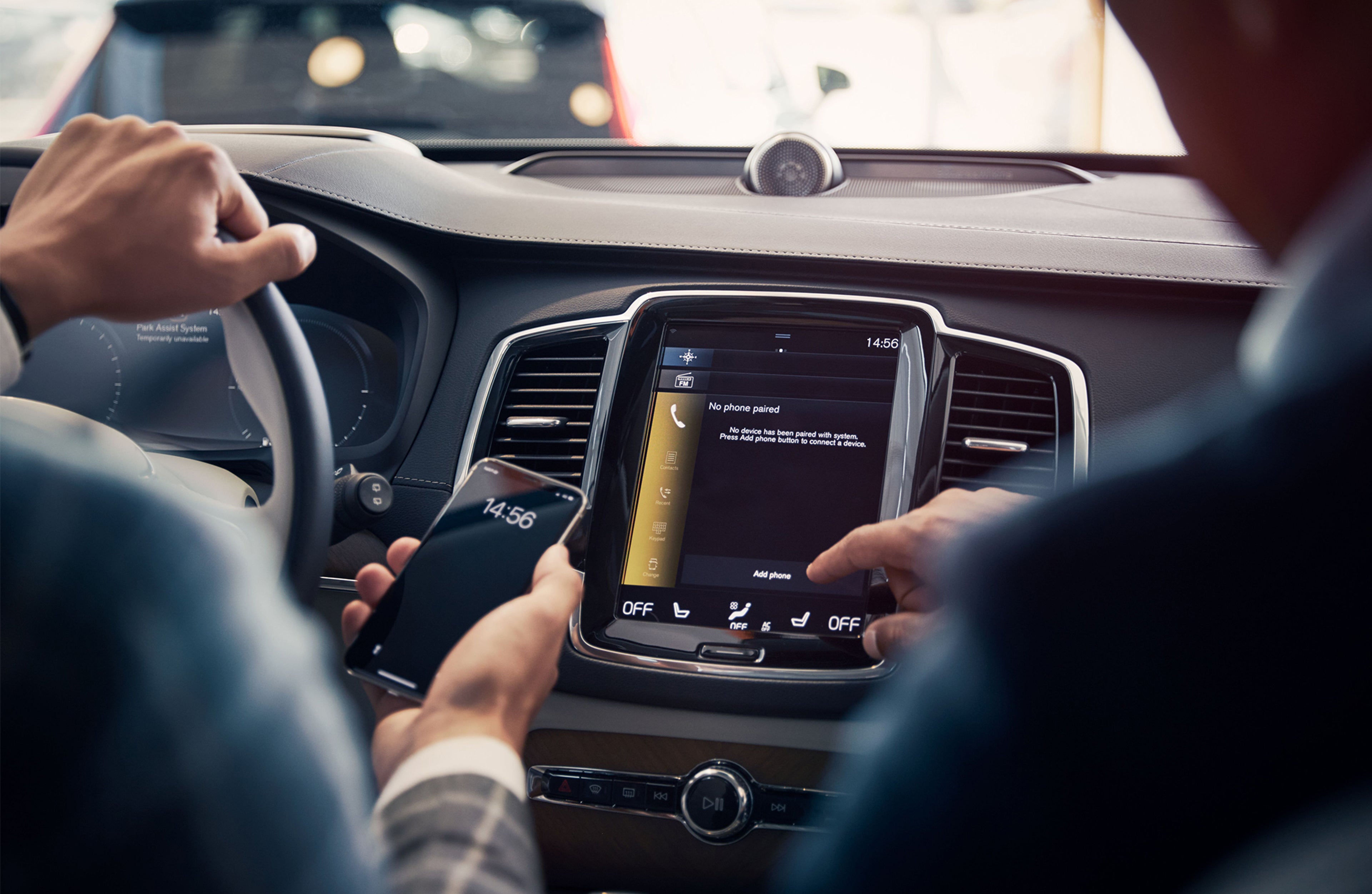 To personer i en bil sett bakfra som peker på en mobil