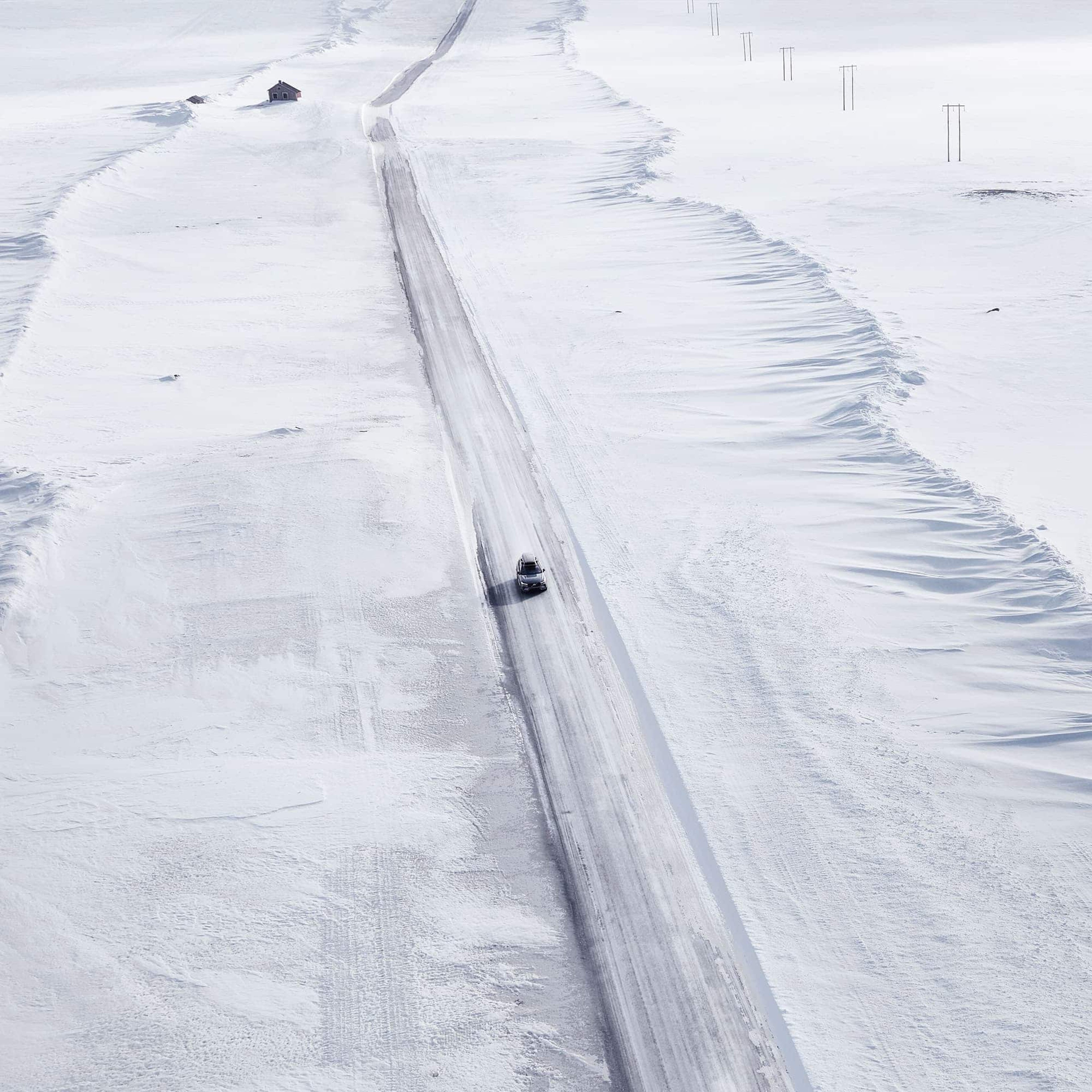 Voiture roule dans un paysage de neige
