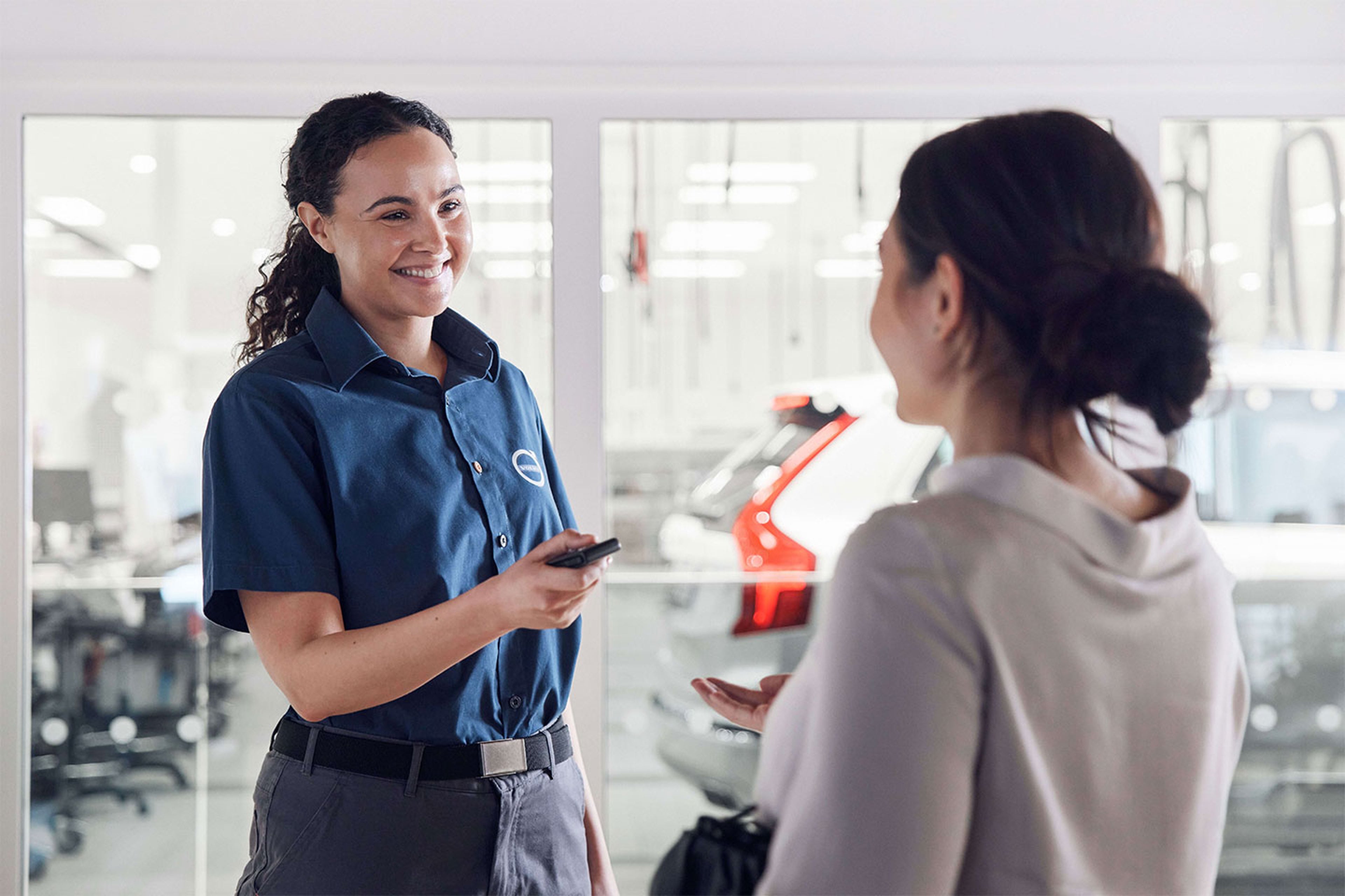 Homme réparant un pare-brise d'une voiture Volvo