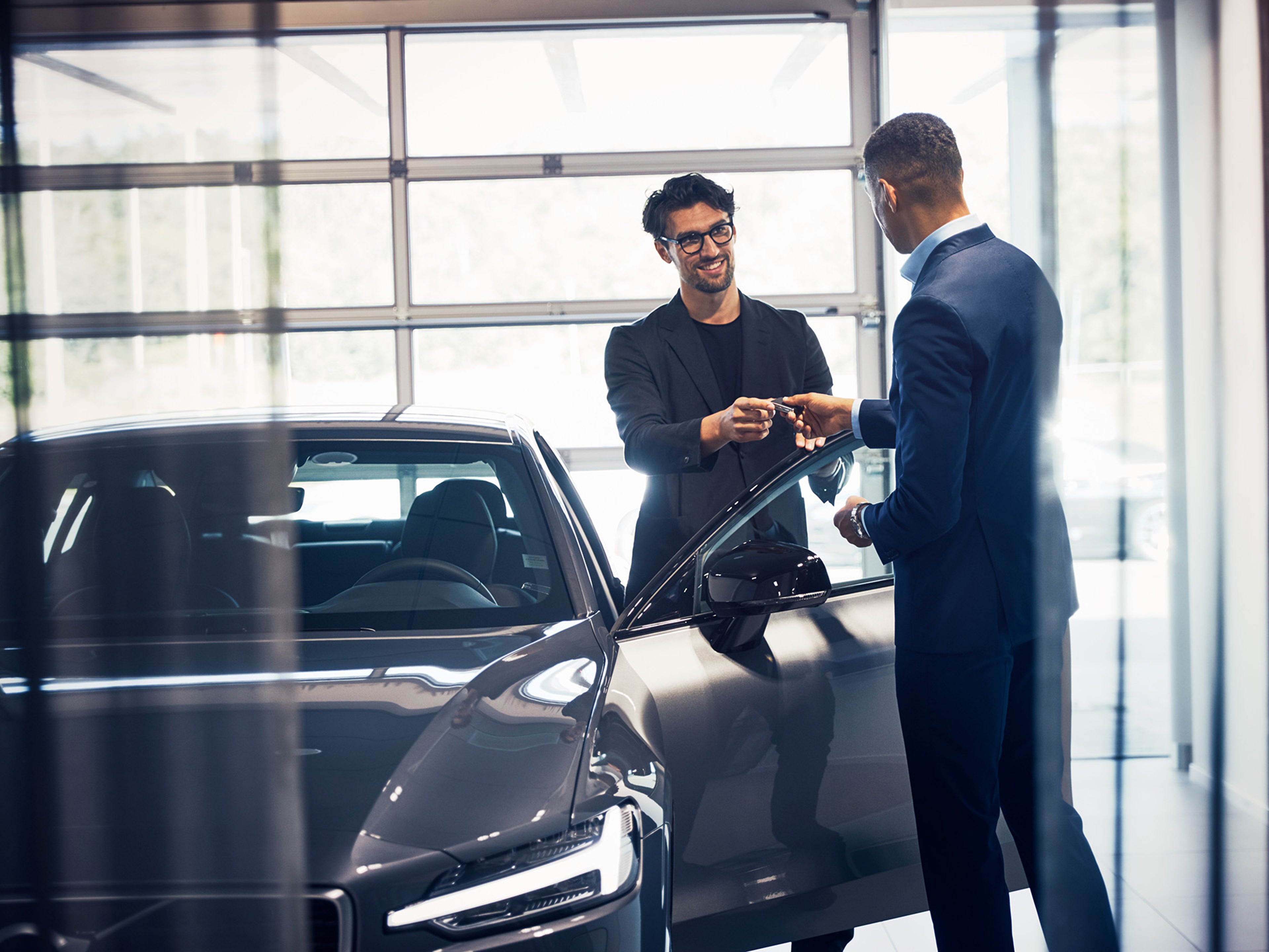 vendedor a passar a chave de um volvo ao cliente